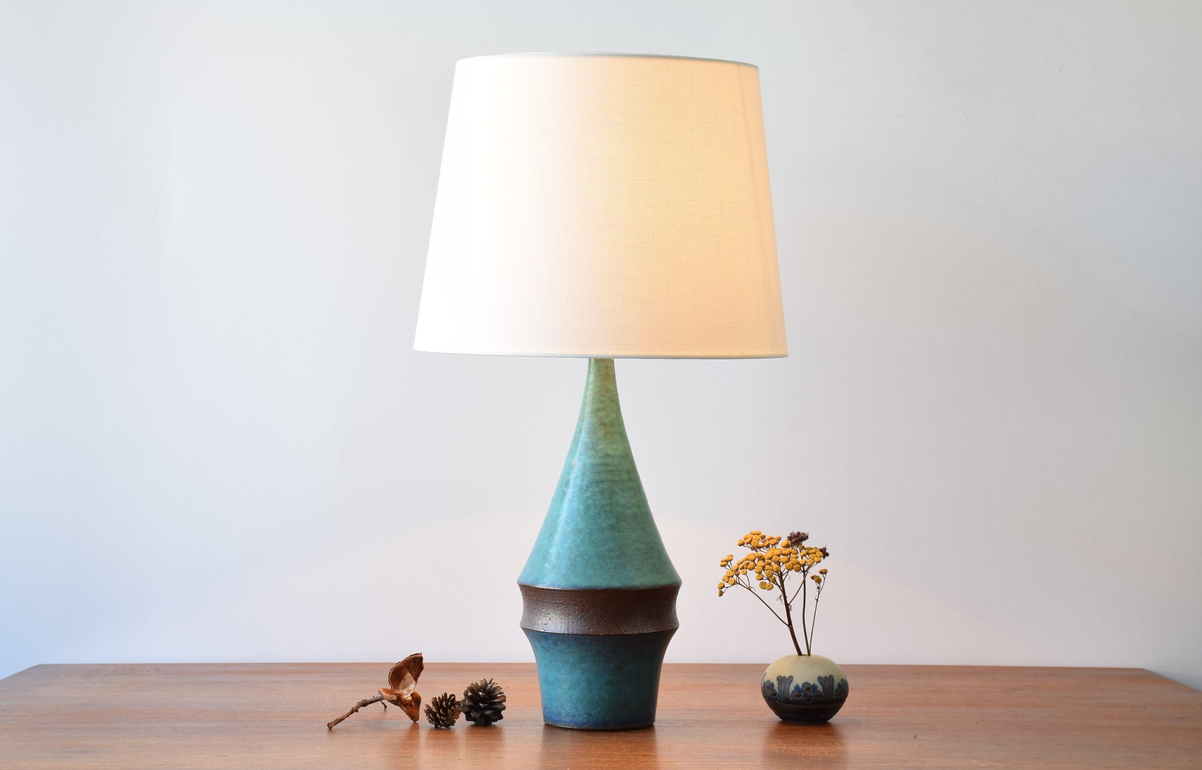 Danish Midcentury tall sculptural table lamp by Marianne Starck for Michael Andersen & Søn.
Turquoise blue glaze and dark brown clay.
Made circa 1960s. 

Included is a new lampshade designed in Denmark. It is made of woven fabric with some texture