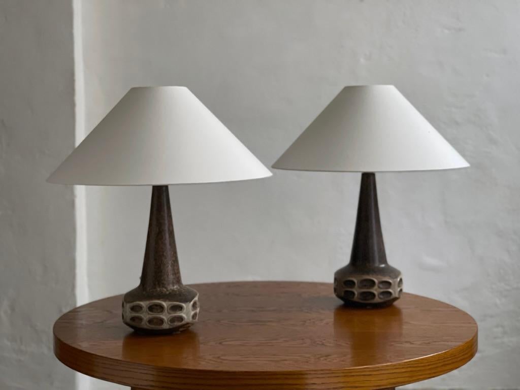 Dieses exquisite Paar Keramiklampen, das von Marianne Starck für Michael Andersen & Son auf der Insel Bornholm entworfen wurde, verkörpert die Essenz des dänischen Designs der Jahrhundertmitte. Diese Lampen aus dem Jahr 1960 sind ein echtes Zeugnis