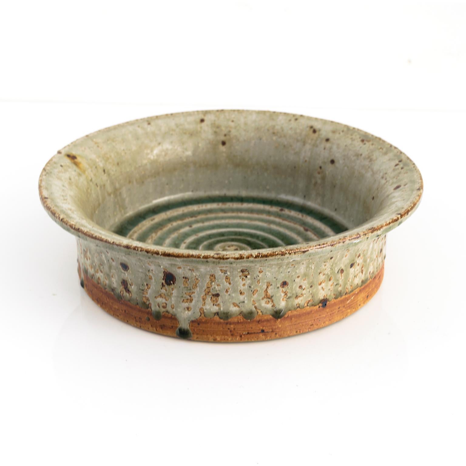 Marianne Westman hand thrown stoneware bowl with flared edge and a spiral with green glaze inside. Exterior is partially glazed and accented with a series of dripping points. Made at Rörstrand Ateljé, Sweden circa 1960, signed.

Measures: