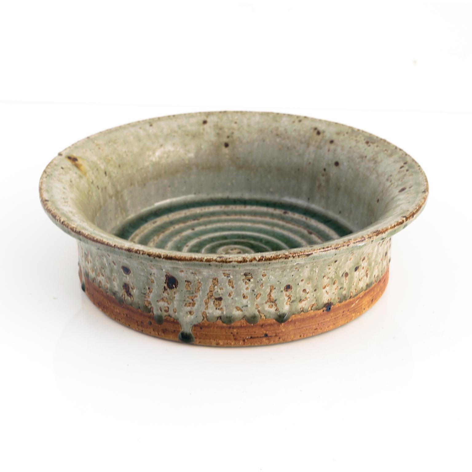 MARIANNE WESTMAN hand thrown stoneware bowl with flared edge and a spiral with green glaze inside. Exterior is partially glazed and accented with a series of dripping points. Made at Rörstrand Ateljé, Sweden circa 1960, signed.

Diameter: 11.5”