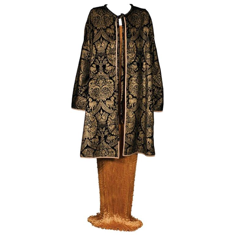 Fortuny's coats often take their inspiration from a myrid of  references,renaissance,persian,arabic .These are often elaborately decorated in historical motifs surprisingly unrelated to the cut  itself.

The hand stenciling is done with real gold