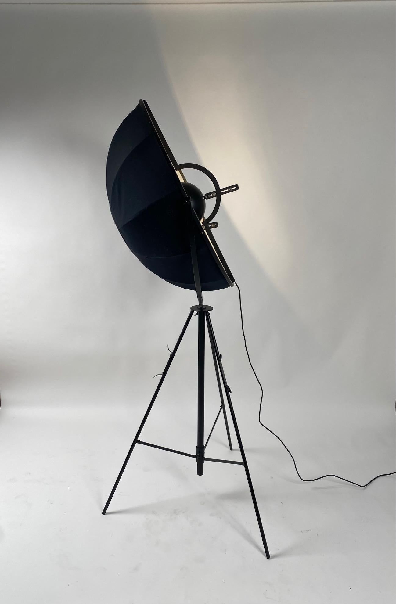 Authentic 1980s version of the Italian iconic floor lamp in metal and fabric conceived by Mariano Fortuny in 1907.
The broad adjustable shade and tripod base aim comfortably diffused indirect light, while an interior reflector hides the bulb (or