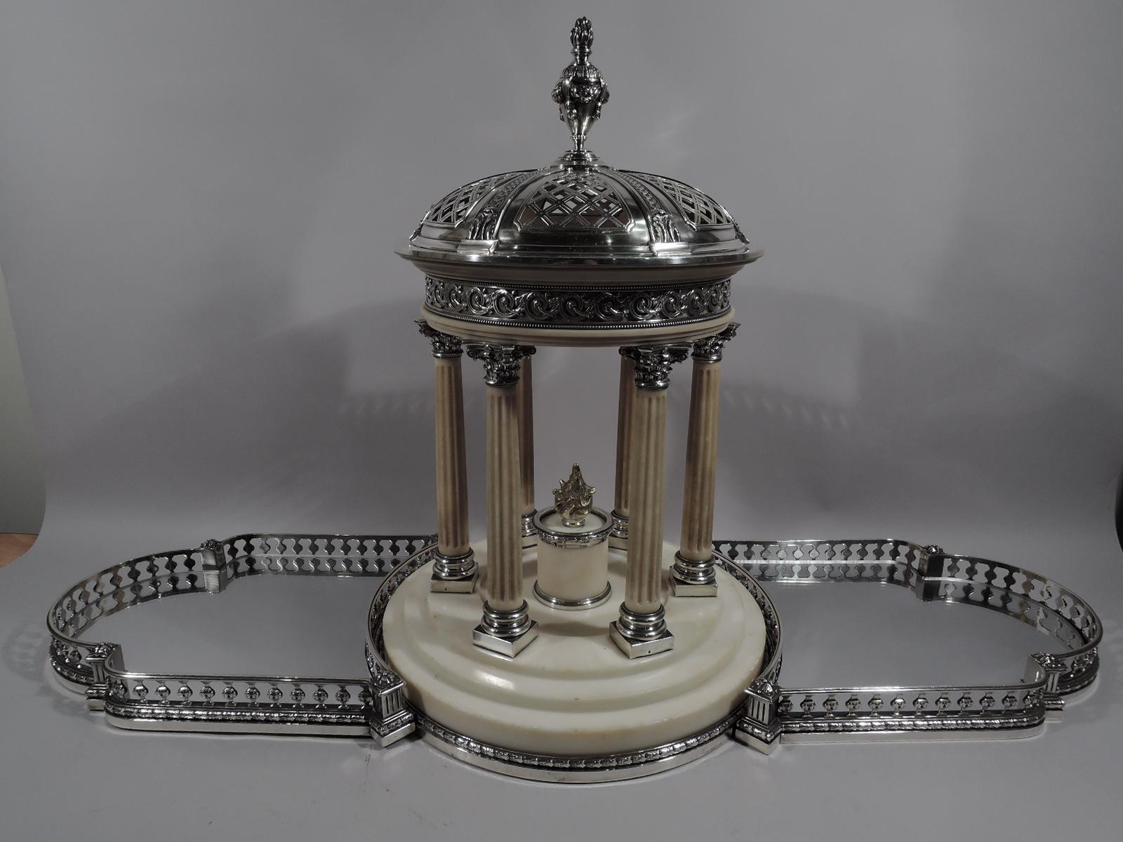 French 950 silver and marble centerpiece based on Marie Antoinette’s garden folly, the Temple d’Amour at Versailles. 

Round stepped marble base with silver imbricated leaf-and-berry border. Six fluted columns with silver base and Corinthian