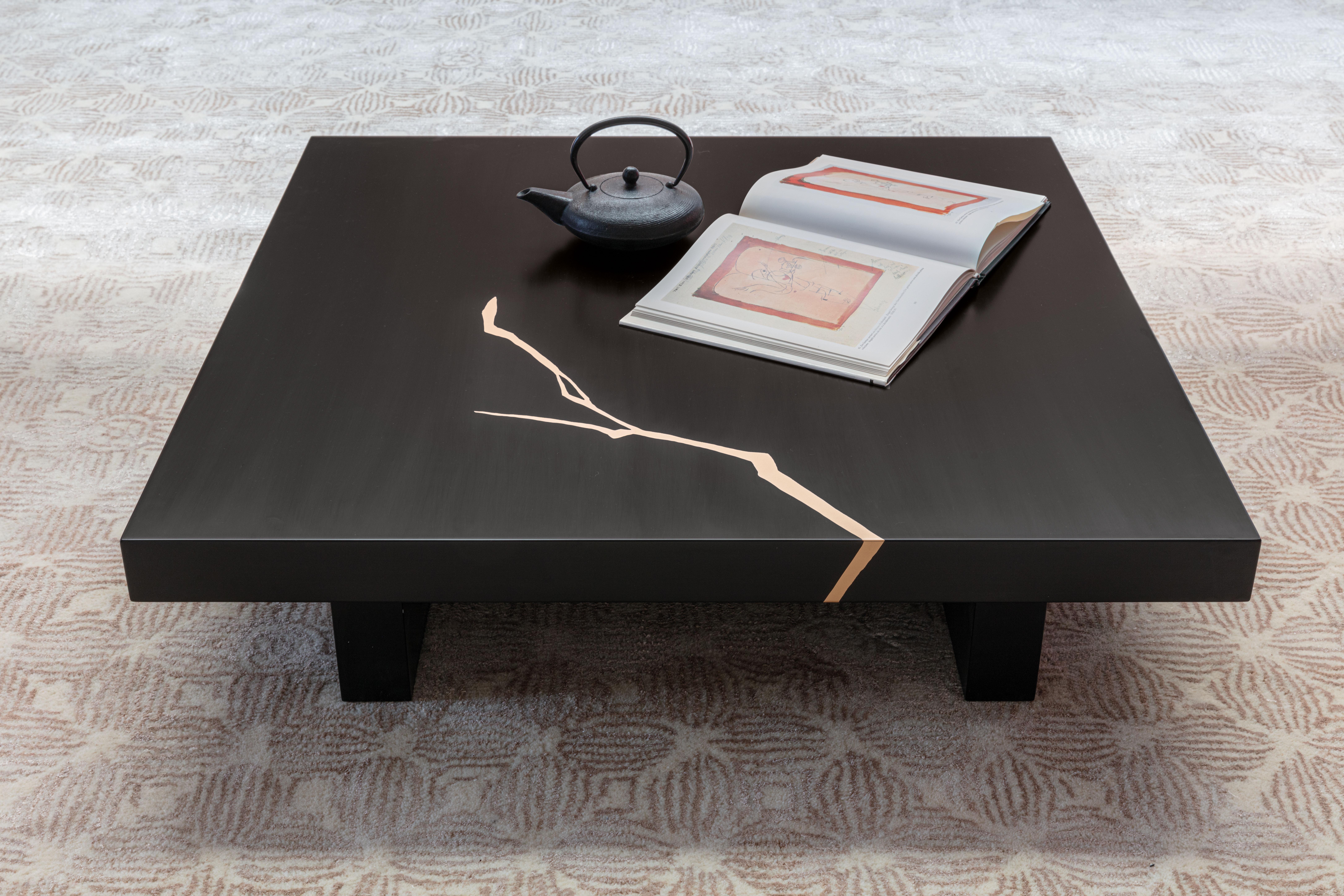 Dieser Couchtisch ist mit einer außergewöhnlichen japanischen Kintsugi-Goldintarsie verziert und ist ein gewagter Blickfang für moderne Innenräume. Vollständig aus Holzfasern gefertigt und mattschwarz lackiert, bietet das schlichte Design eine