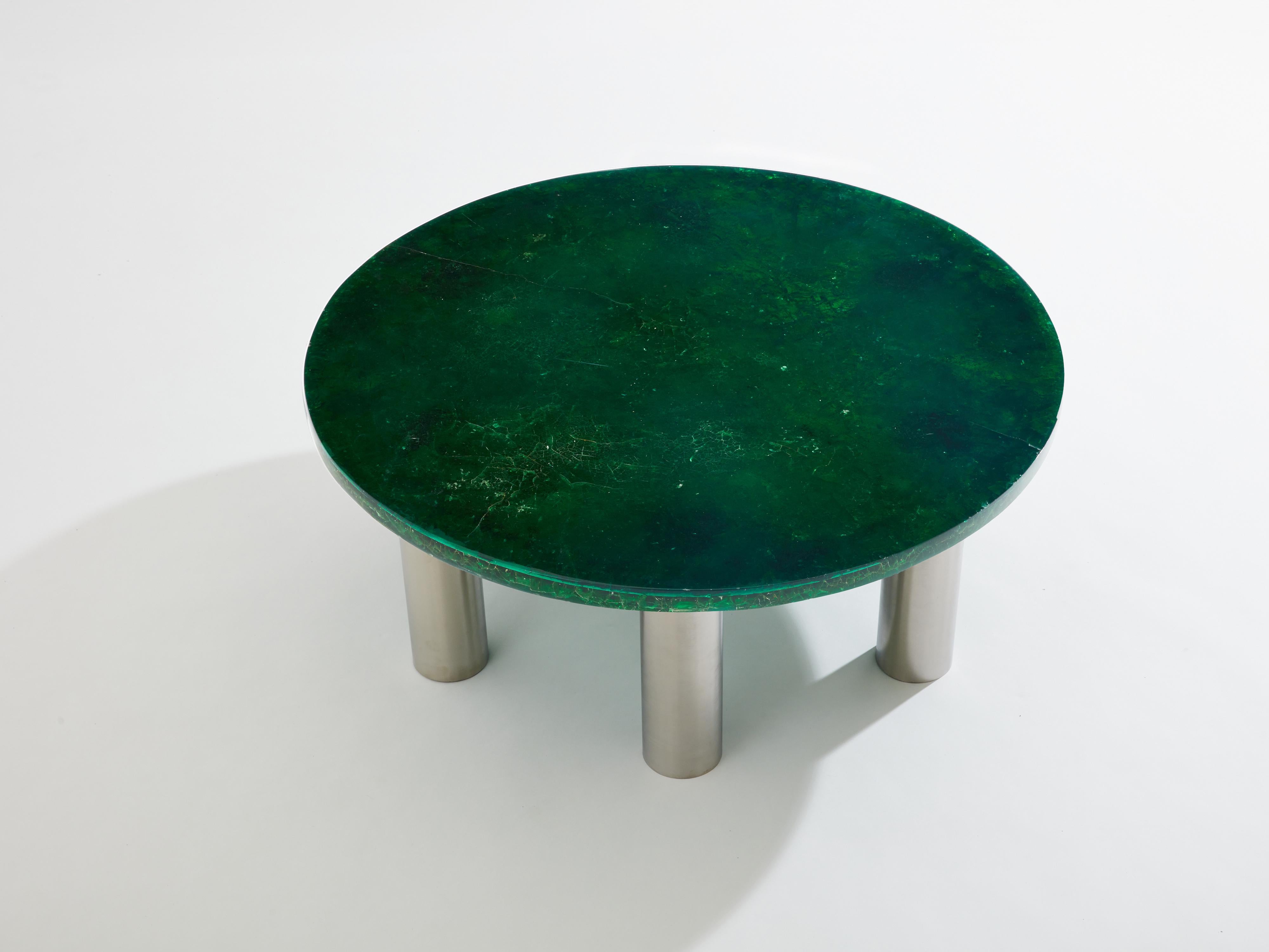 This round coffee table, designed by Marie-Claude de Fouquières in the 1970s, is a remarkable piece. Its tabletop is crafted from green fractal resin with golden reflections, reminiscent of the cosmos. Fractal resin is the result of a complex
