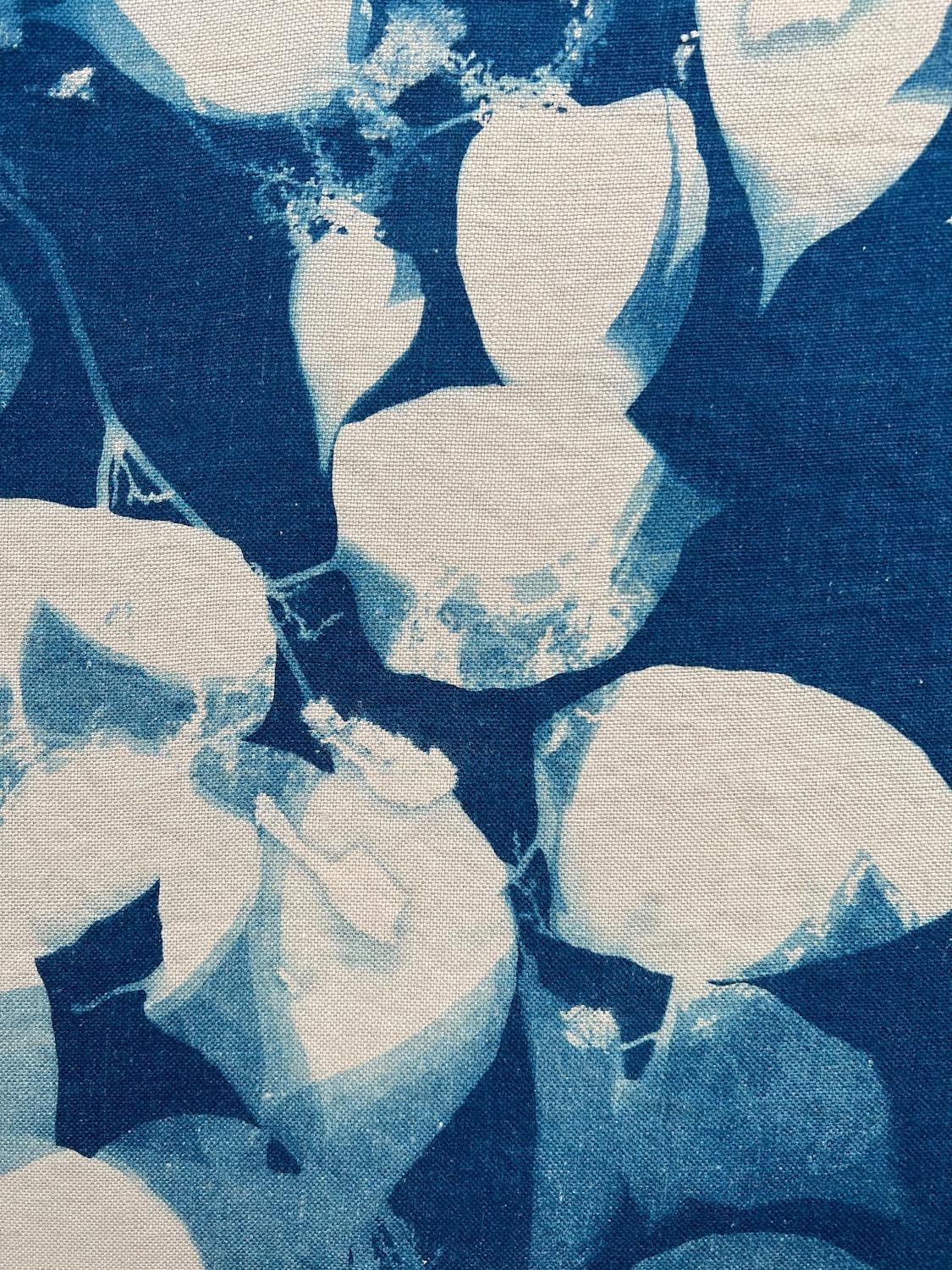 Marie Craig's 'Knotweed’ is an original deep blue photograph of leaves and branches of the Japanese Knotweed plant. This piece was created using cyanotype, an early photographic process which uses sunlight to expose specially treated linen,