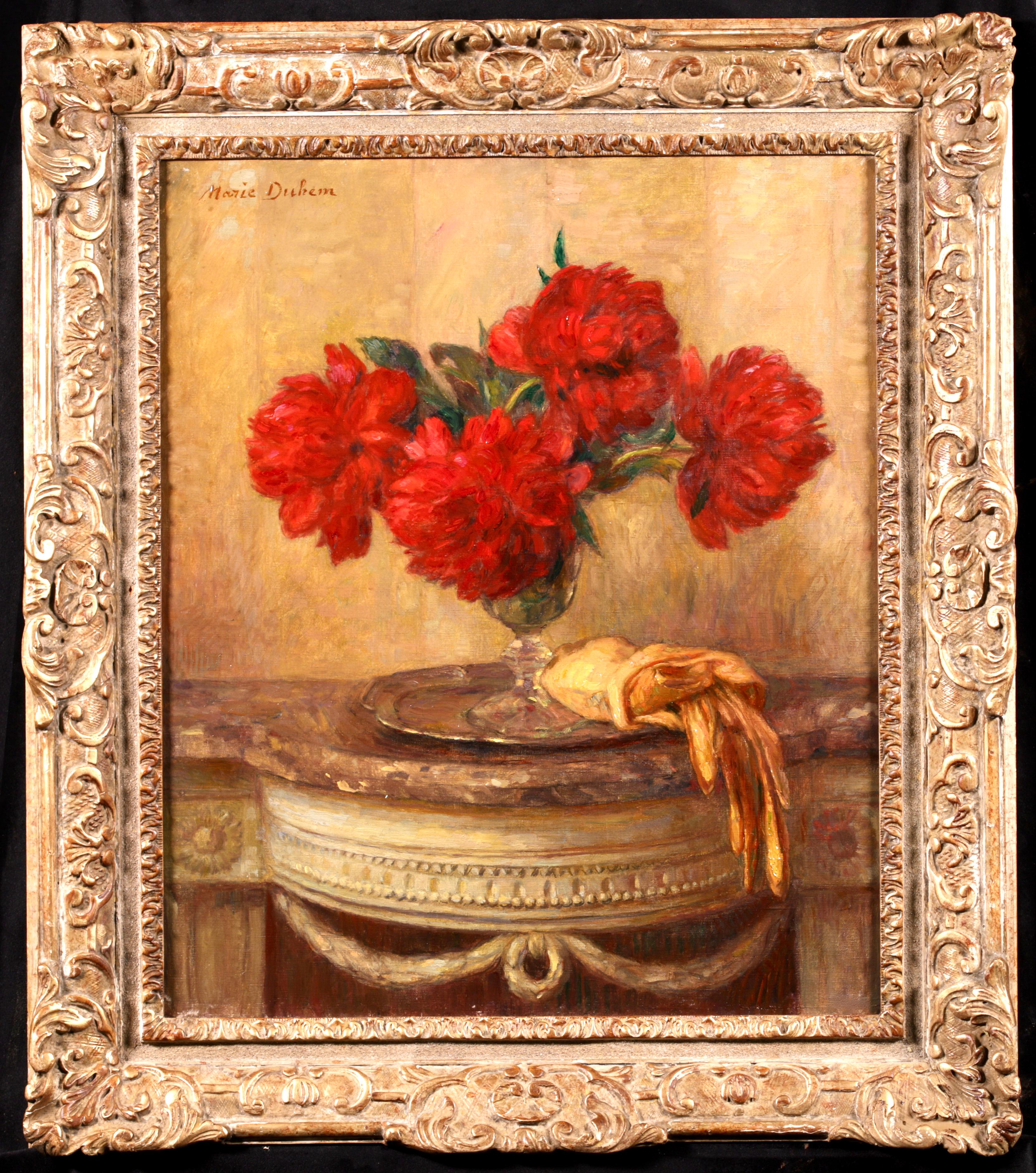Signed and titled still life oil on canvas circa 1900 by French impressionist painter Marie Duhem. The work depicts red peonies in a glass vase which is sitting on a silver plate with yellow gloves placed beside it.

Signature
Signed upper left and