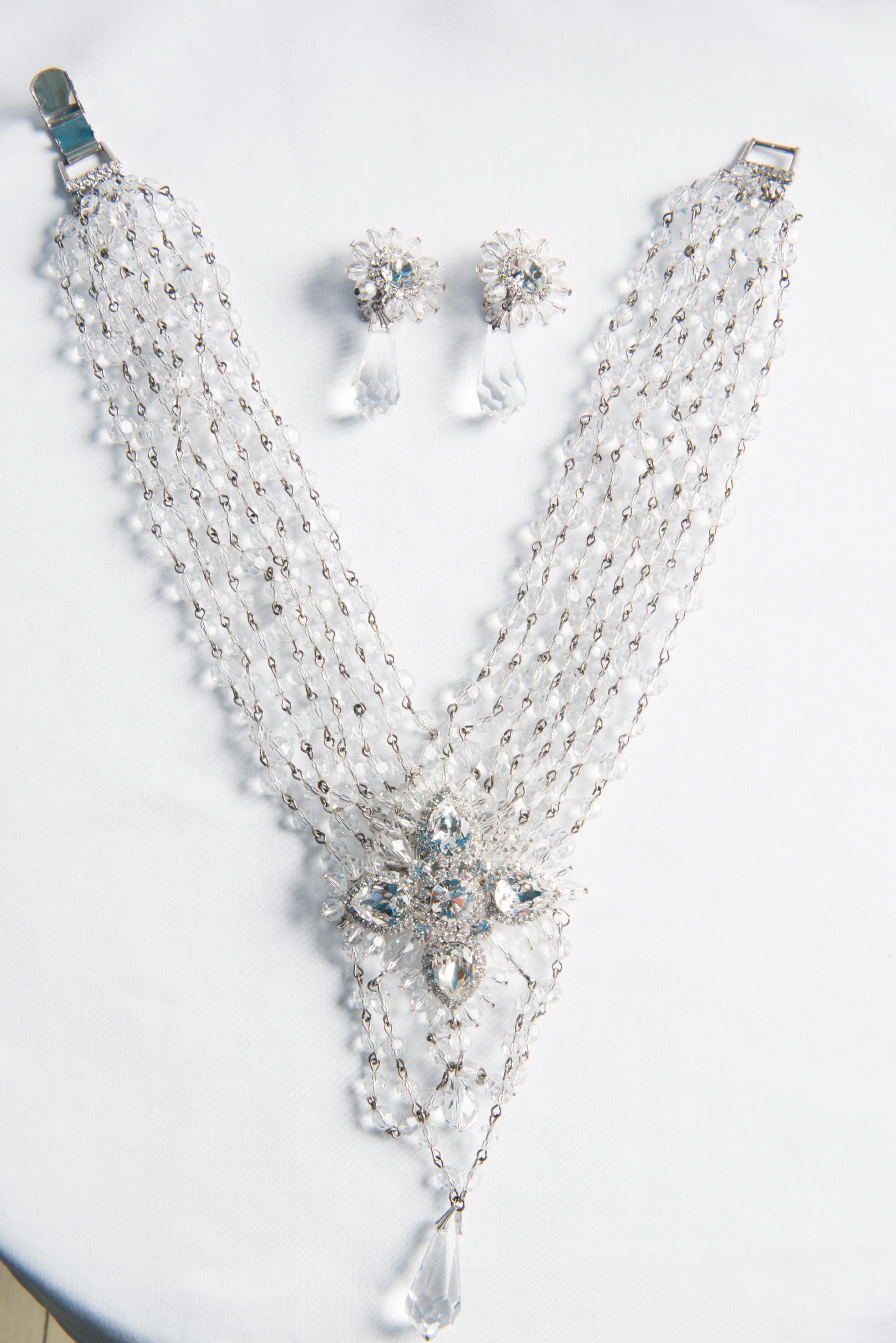  A stunning Marie Ferre eight strand crystal and rhinestone necklace and earring set. Signed. The necklace possesses a large crystal and rhinestone medallion with four cut pear shaped rhinestones and one round brilliant cut center rhinestone. Center