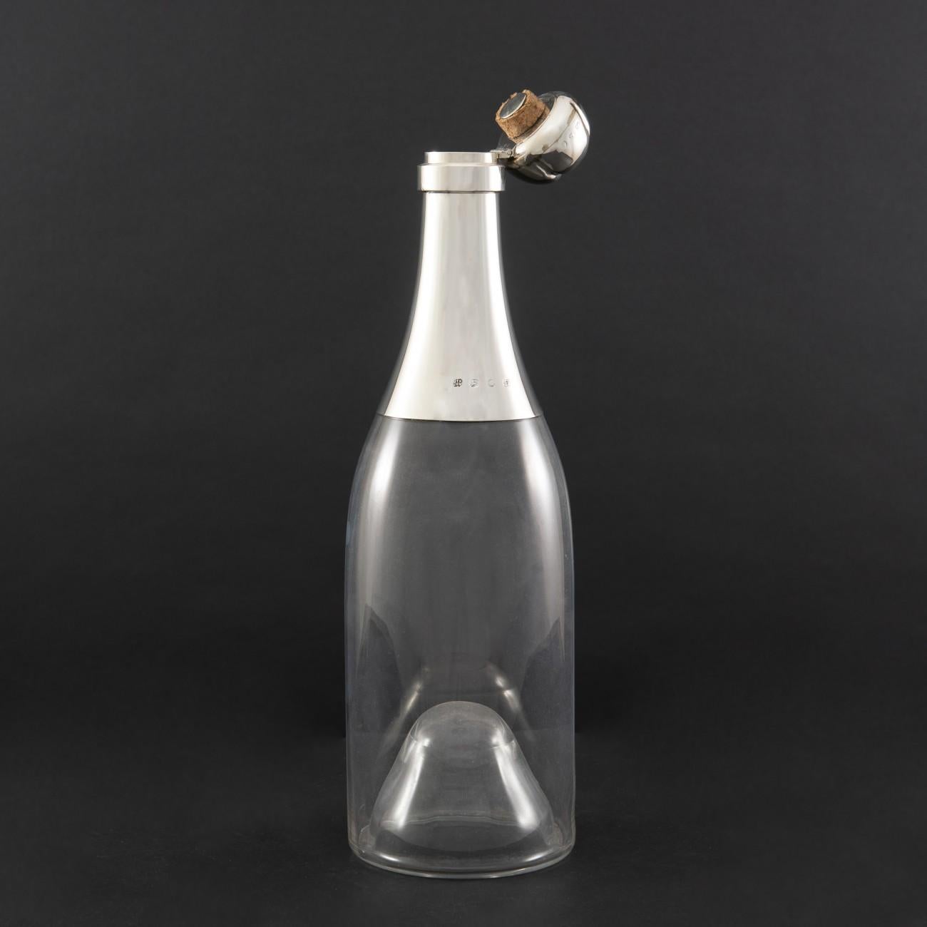 Wonderful champagne bottle decanter with a three bottle capacity. The glass body is fluted but in a truly elegant fashion, on the inside only; so that the outside surface of the decanter remains smooth. The silver neck and hinged stopper have
