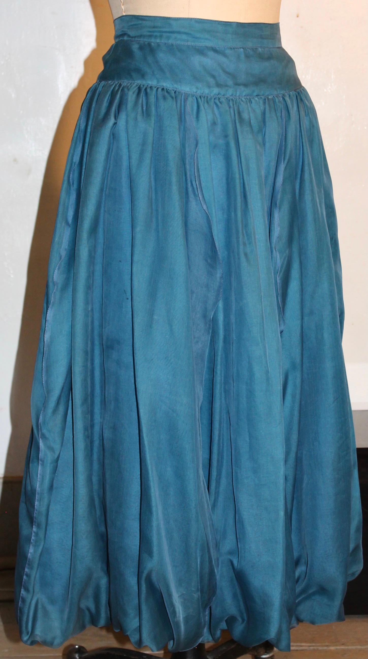 La jupe est entièrement doublée de soie bleue et présente un effet légèrement bouffant à l'ourlet.