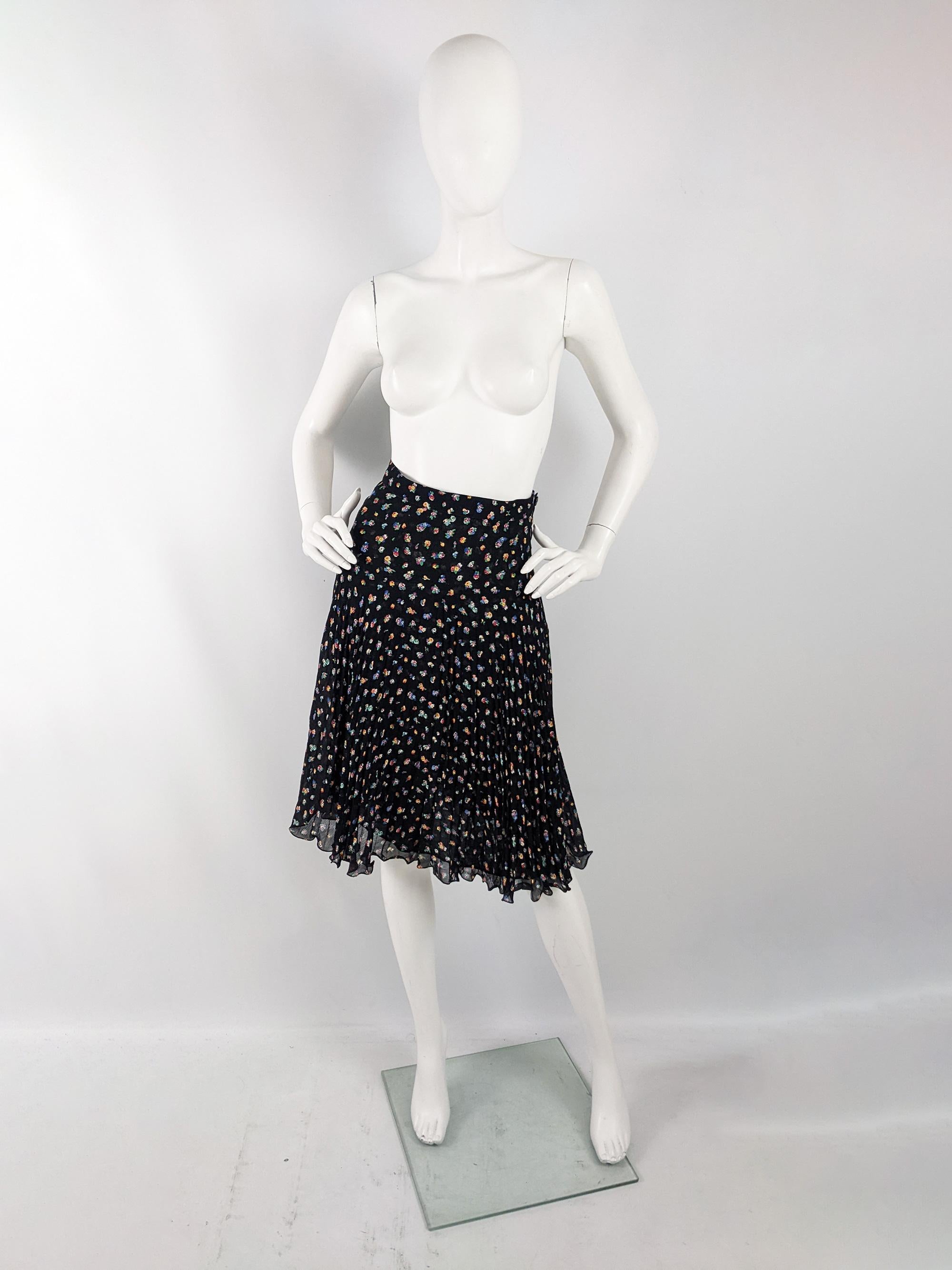 A cute vintage womens skirt from the 80s by quality Italian designer, Mariella Burani for Amuleti. In a lightweight black slightly sheer georgette fabric with a floral print thrroughout. It has a high waist and pleats throughout.

Size: Unlabelled;