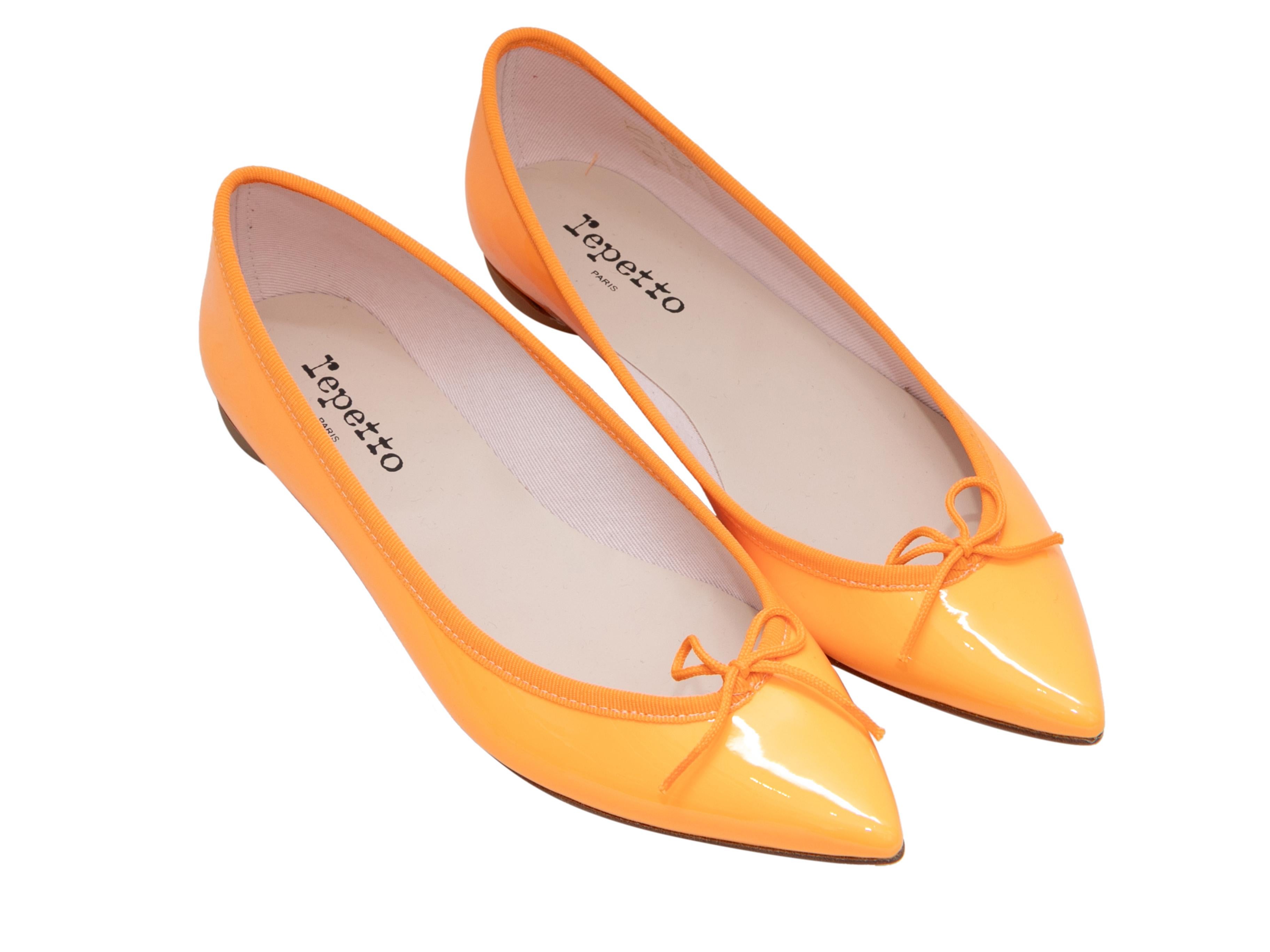 Marigold patent leather pointed-toe ballet flats by Repetto. Grosgrain trim and bow accents at tops. 0.25