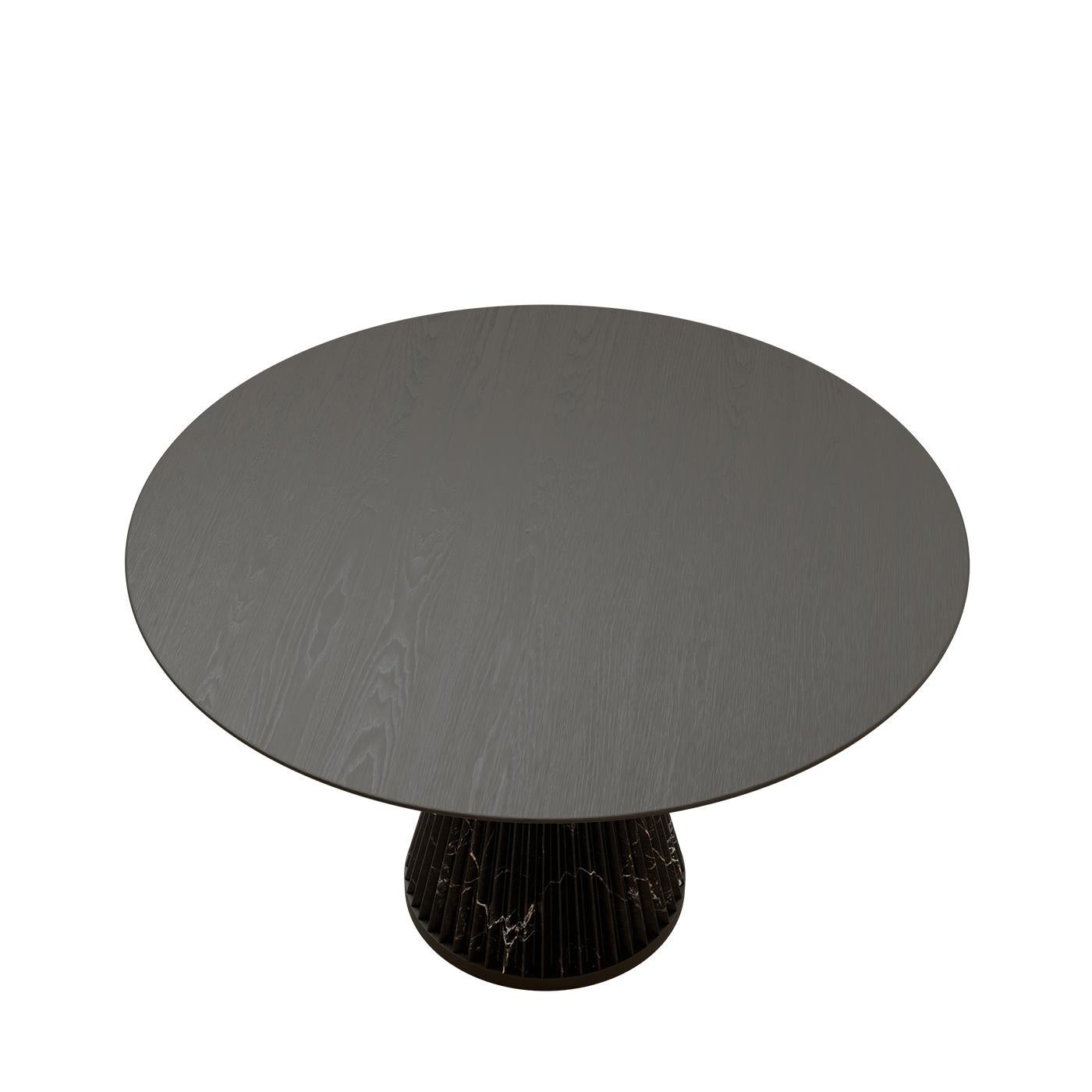 La table Nature allie avec élégance la grandeur du marbre Dark Emperador à la beauté naturelle du bois de frêne. Ses lignes raffinées mettent en valeur le savoir-faire de Morelato et la vision du designer Libero Rutilo, apportant une touche de