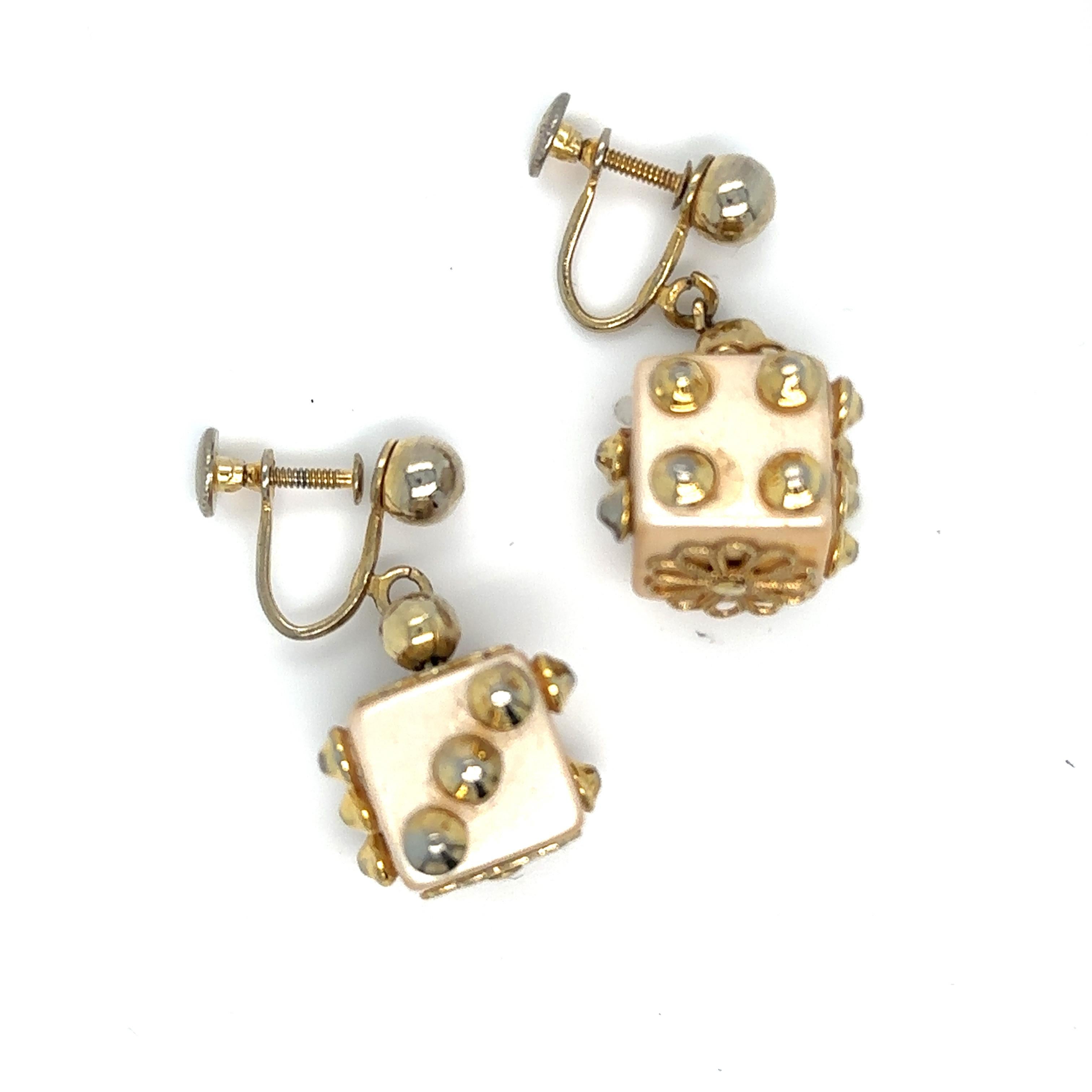 Pulsera y pendientes con dados de resina moldeada acentuados con tachuelas de metal dorado (faltan algunas). 
Pulsera 7 pulgadas
Descubre la encantadora historia que se esconde tras estos exquisitos pendientes y pulsera de dados, un sentido regalo