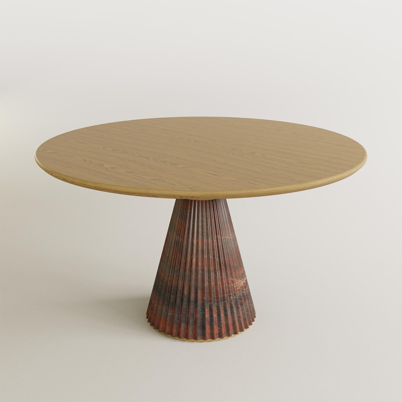 La table Nature allie avec élégance la grandeur du marbre Rosso Levanto à la beauté naturelle du bois de frêne. Ses lignes raffinées mettent en valeur le savoir-faire de Morelato et la vision du designer Libero Rutilo, apportant une touche de