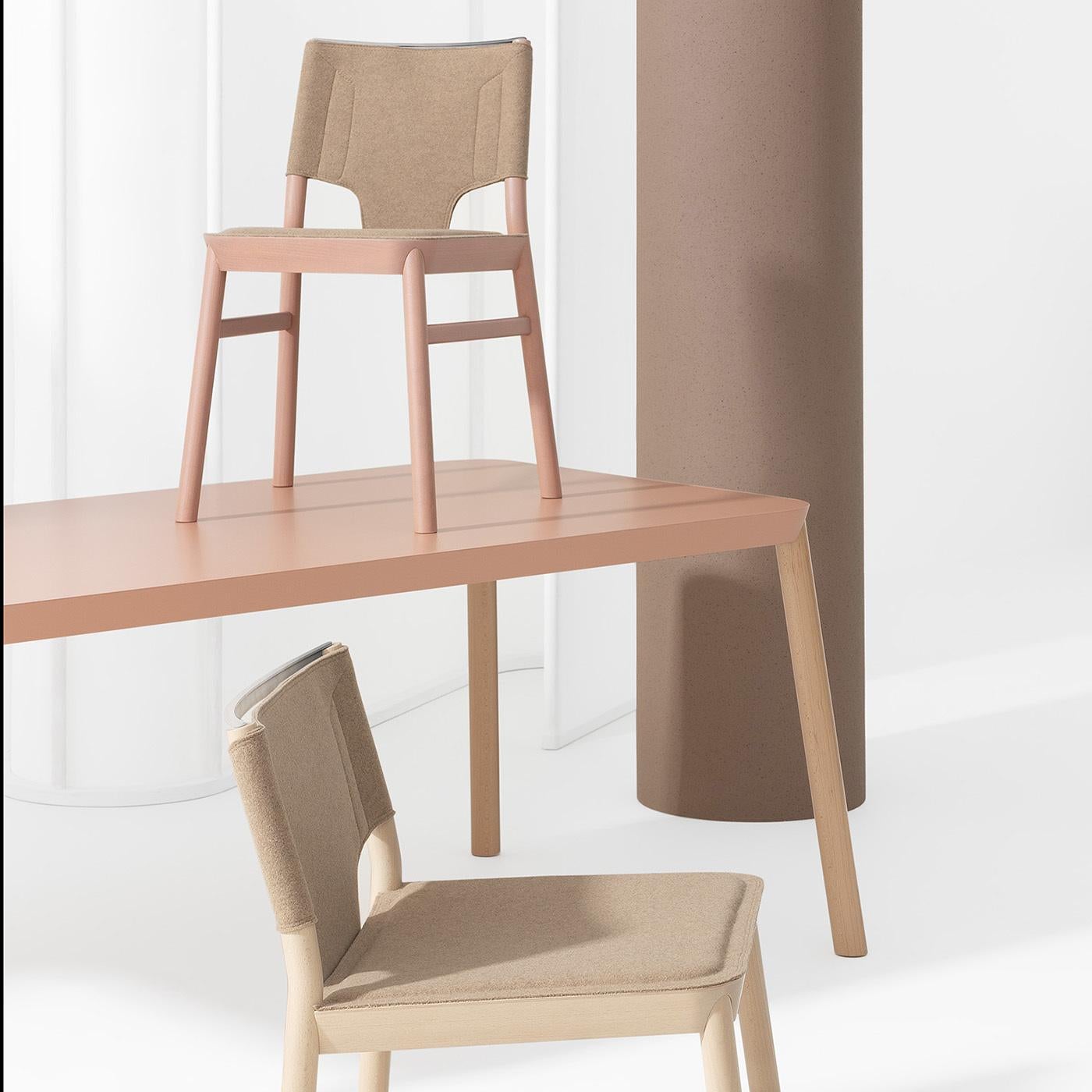 This refined version of the Marimba chair will effortlessly complement modern interiors with its sophisticated yet sober aesthetic. The sleek frame in solid beech is tinted in beige red and features slightly slanted legs as support for the open