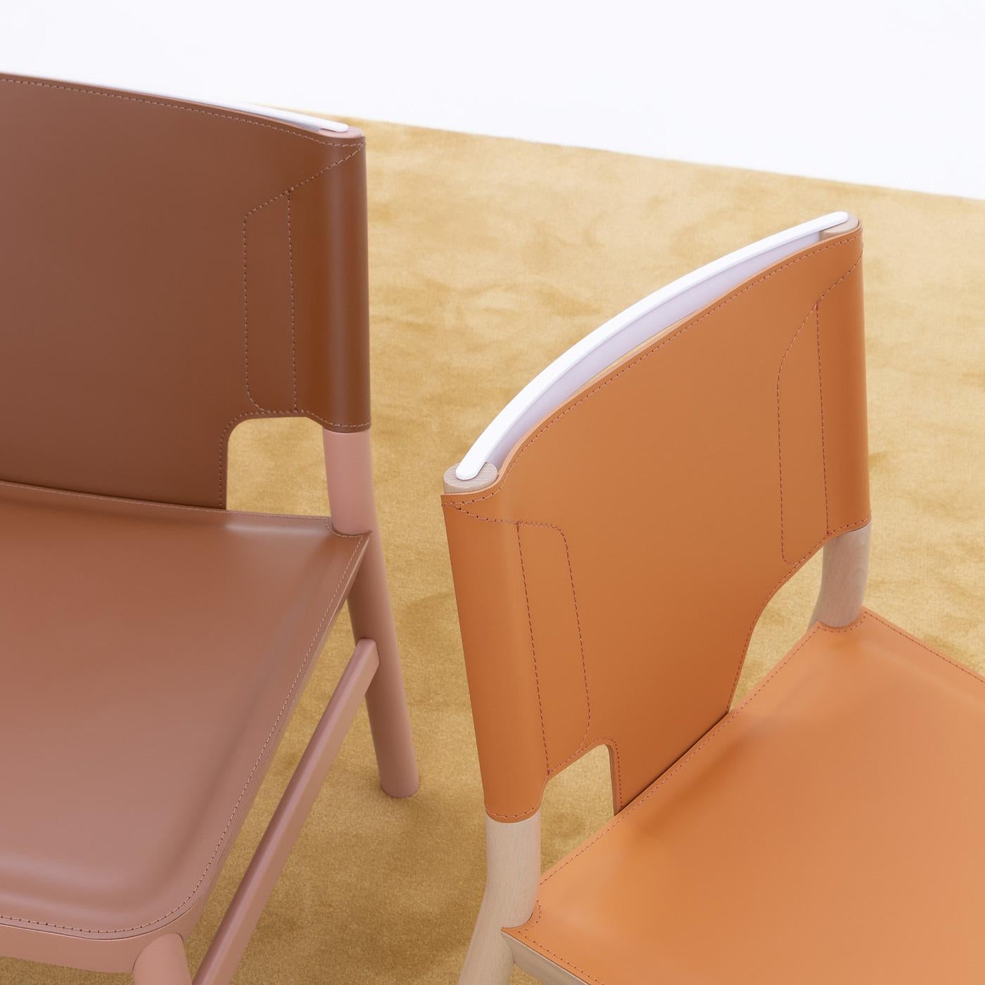 Solid beechwood and orange leatherette create a happy harmony between stability and agility in the Marimba dining chair by Emilio Nanni. Designed in 2018, the dining chair comes from a complete collection of seating options and comes in a variety of