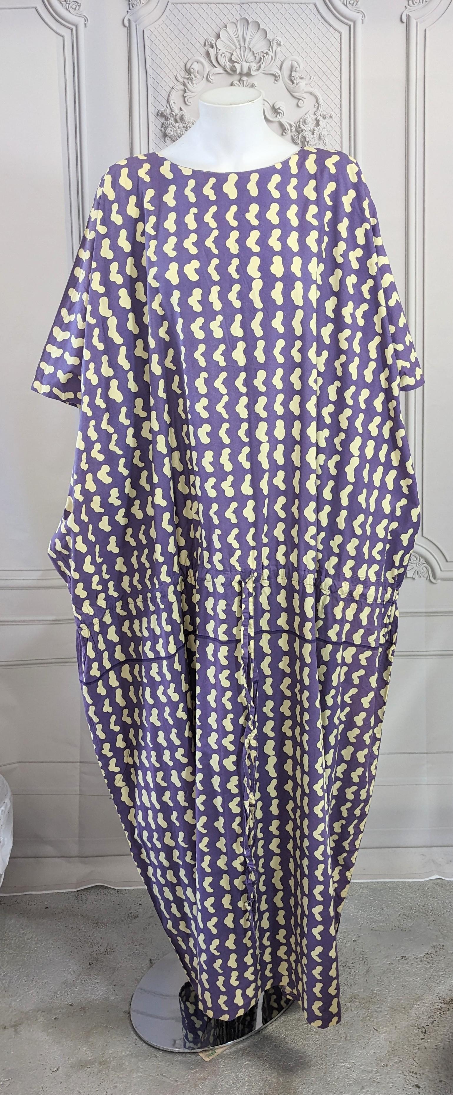 Charming Marimekko Cotton Drawstring Caftan from the 1970's. A huge folded cotton rectangle in signature Marimekko graphic print has one drawstring just below the hip to adjust as needed. The print also has a purple line printed just below