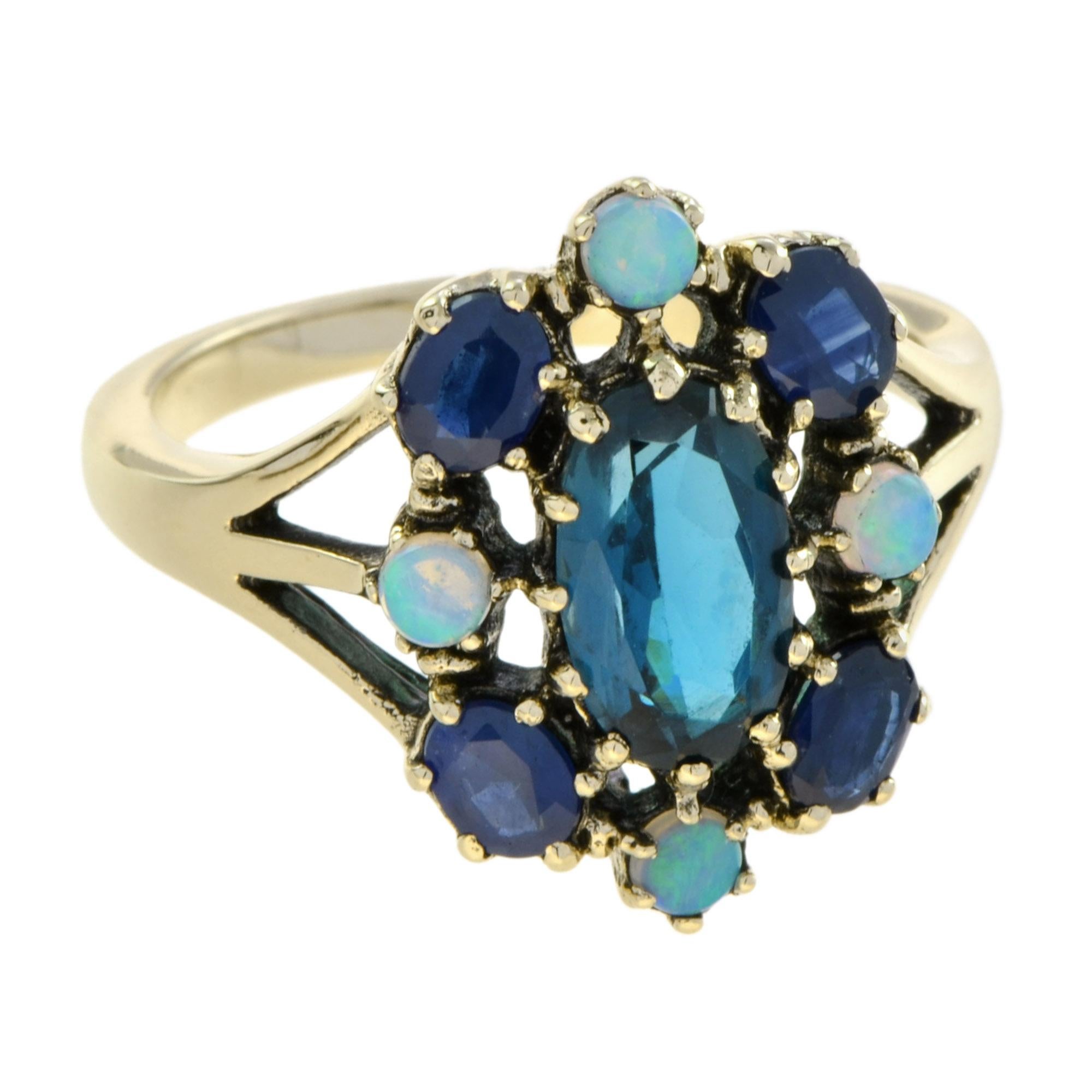 A perfect gift for a friend or family member, this blue gemstones ring is fashioned in popular 9k yellow gold and features a cluster of sapphires and opals surrounding the center oval London blue topaz. 

Ring Information
Metal: 9K Yellow Gold -