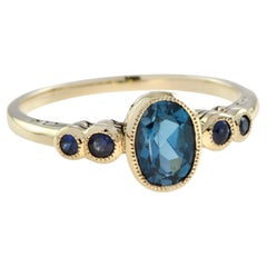 Marin Solitär-Ring aus 9 Karat Gelbgold mit ovalem Londoner blauem Topas und Saphir
