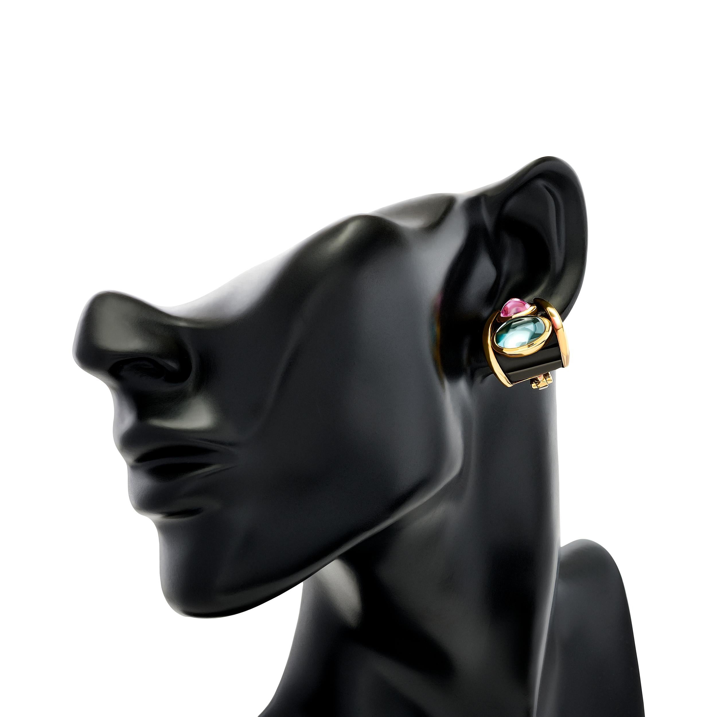 Les magnifiques boucles d'oreilles en émail noir à la topaze bleue et à l'améthyste de Marina B., où les pierres précieuses vibrantes et l'artisanat exquis convergent pour créer un chef-d'œuvre à porter.

Les deux pierres précieuses ovales en topaze