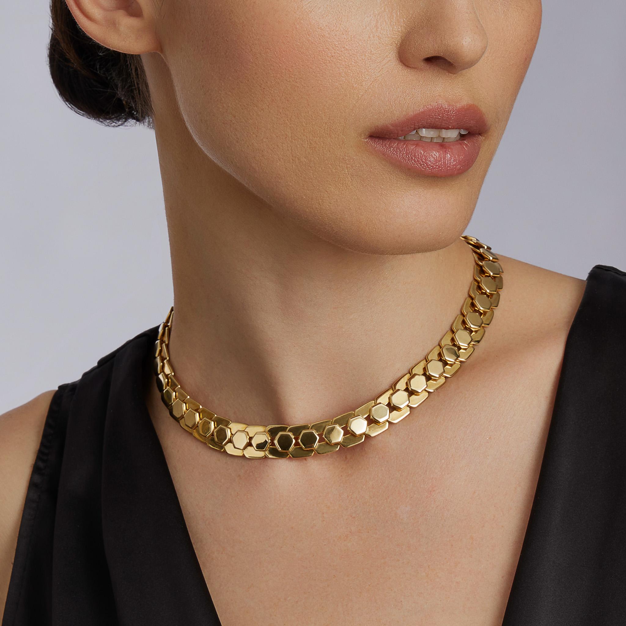 Creata da Marina B. nel 1987, questa collana è realizzata in oro 18 carati. È composto da due linee di maglie esagonali, una progettata come forme solide che sormontano maglie aperte sovrapposte. Snella e ingegnosamente costruita, questa collana