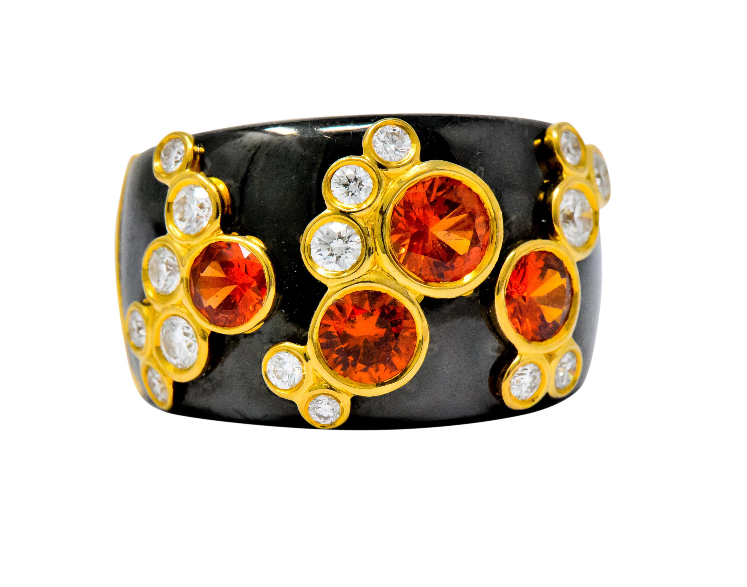 Featuring a wide band with 4 round cut orange sapphires weighing approximately 2.20 carats total, bright deep vivid orange

Accented with round brilliant cut diamonds, weighing approximately 0.60 carats, F/G color and VS clarity

All stones bezel