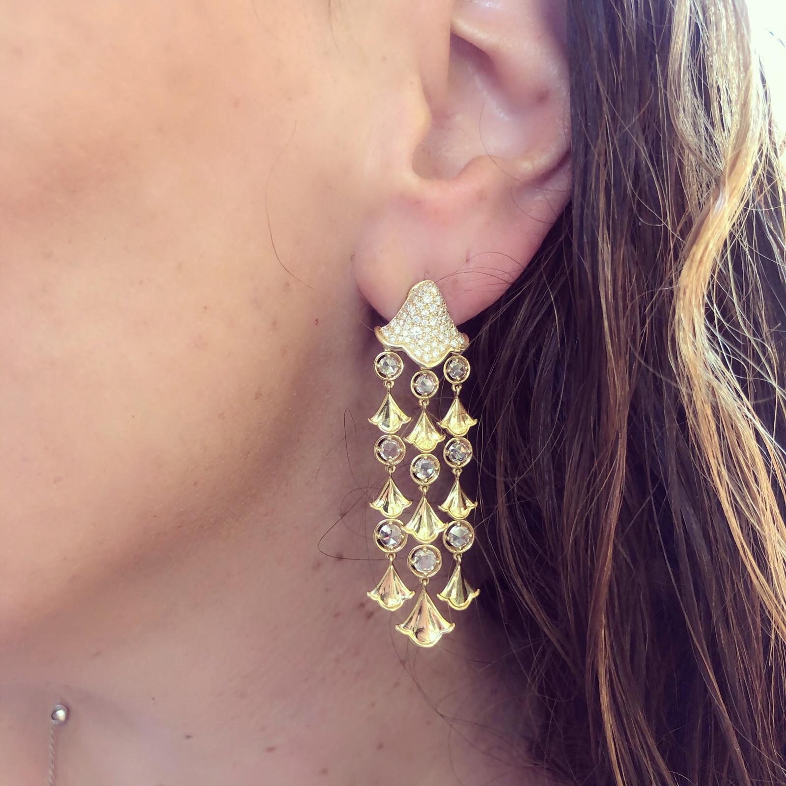 These elegant chandelier earrings will accent any outfit! By Marina B. of the famed Bulgari family, the 18k gold pendants are designed with pave-set round brilliant-cut ginko leaf tops, suspending strands of gold ginko leaves alternating with