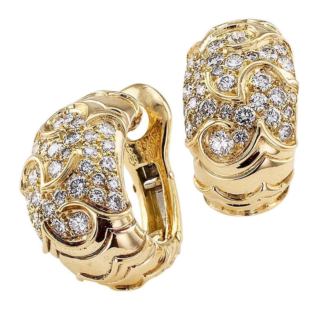 Marina B 1990s diamond and gold half hoop ear clips. The half hoop designs are decorated by a scrolling motif in relief over the surface of the earrings, pave at the centers with round brilliant-cut diamonds totaling approximately 2.75 carats,