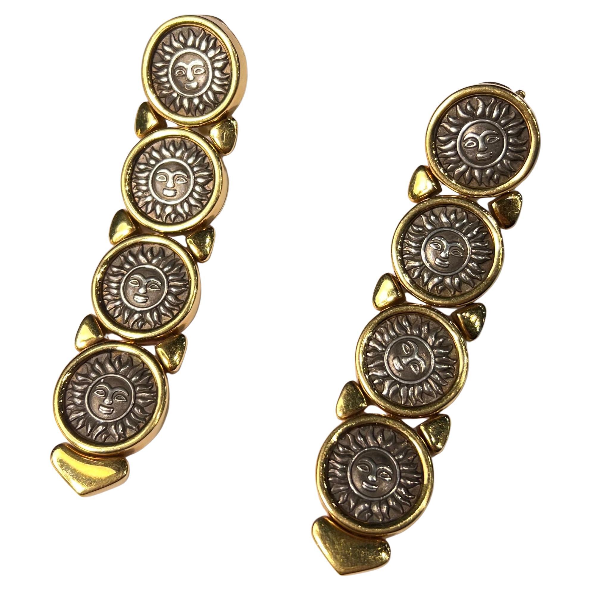 MARINA B 'DONATELLA' MÜNZE UND OHRHÄNGER AUS GOLD, 1987
Jeweils in Kronleuchterform, eingefasst in eine Reihe silberner Scheiben mit Sonnenmotiv, jede in einer polierten Goldeinfassung
Metall: 18 Karat Gelbgold und abgedunkelte