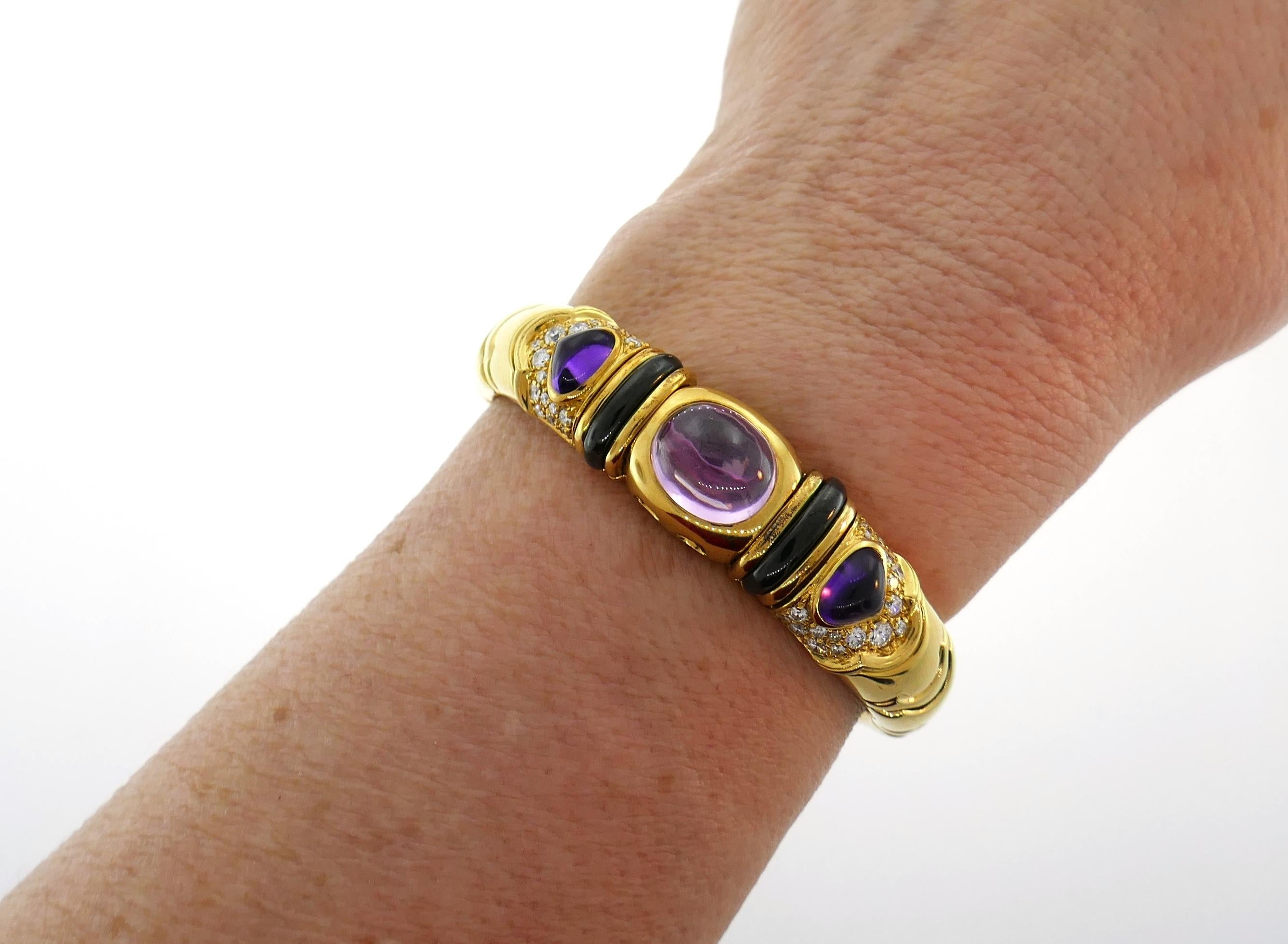 Colorful and chic bangle created by Marina B in 1980s. Elegant and wearable, the bracelet is a great addition to your jewelry collection. Features an oval cabochon pink tourmaline set in 18 karat yellow gold accented on each side with a pear