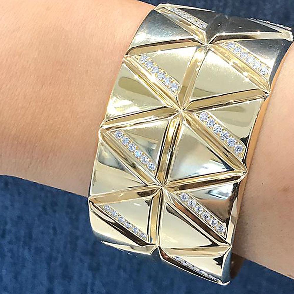 A sleek 18k gold and diamond torque bangle by Marina B with a geometric stacked triangle motif and set with 2.25 carats of white diamonds.
Bangle size 6.25.

No. TMWJ-190506-2