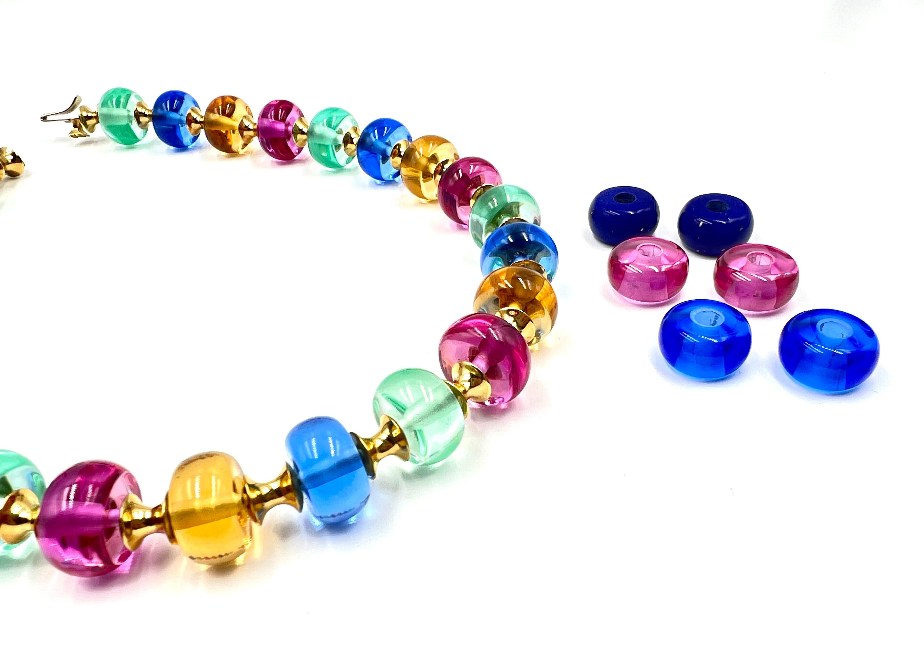 Spherical glass beads, approximately 15 x 8mm each, in blue, pink, aqua green, and orangish yellow colors.  18kt gold, convex spacer links with matching style clasp marked 