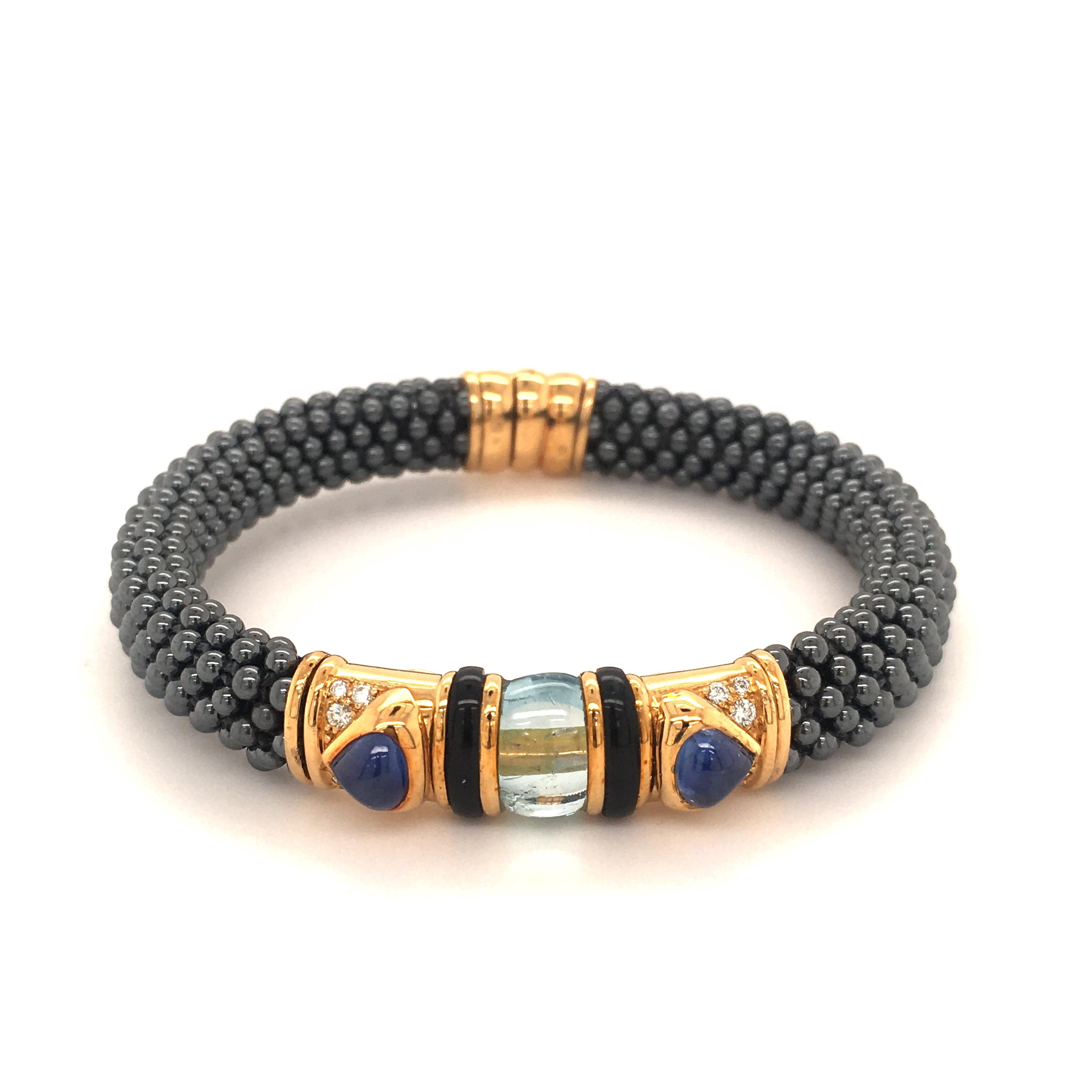 Marina B 'Najwa' 1982 Bracelet braided with Hematite beads.
2 blue Sapphire-Cabochons and an Aquamarine are set in 18 kt Yellow Gold with 12 Diamonds.
The sporty and uncomplicated look makes it the perfect accessory for the summer.
(Bracelet is