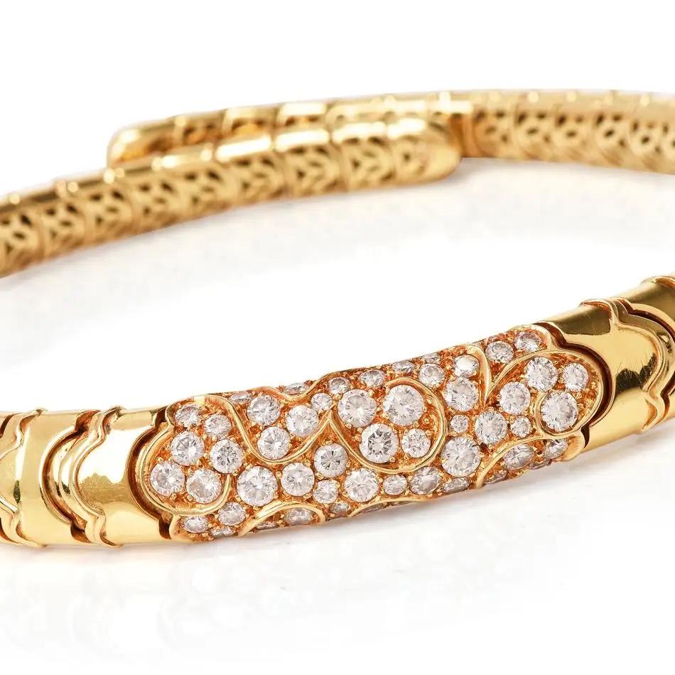 This timeless designer diamond choker is crafted in solid 18-karat yellow gold, weighing 104.9 grams and measuring 14” long x 12mm wide. Pave-set in a centered swirl design with 50 round-cut diamonds, collectively weighing 3.90 carats, graded E-F