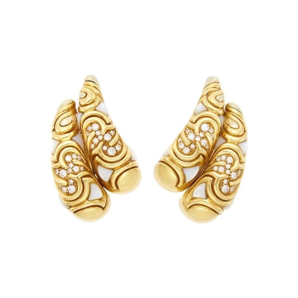 A pair of Marina B gold, mother-of-pearl and diamond earclips crafted in 18kt gold. Made in Italy.  

The tapered bombé paisleys of fancy-shaped gold panels tipped by white gold accents, spaced by triangular buff-topped mother-of-pearl, set with 52