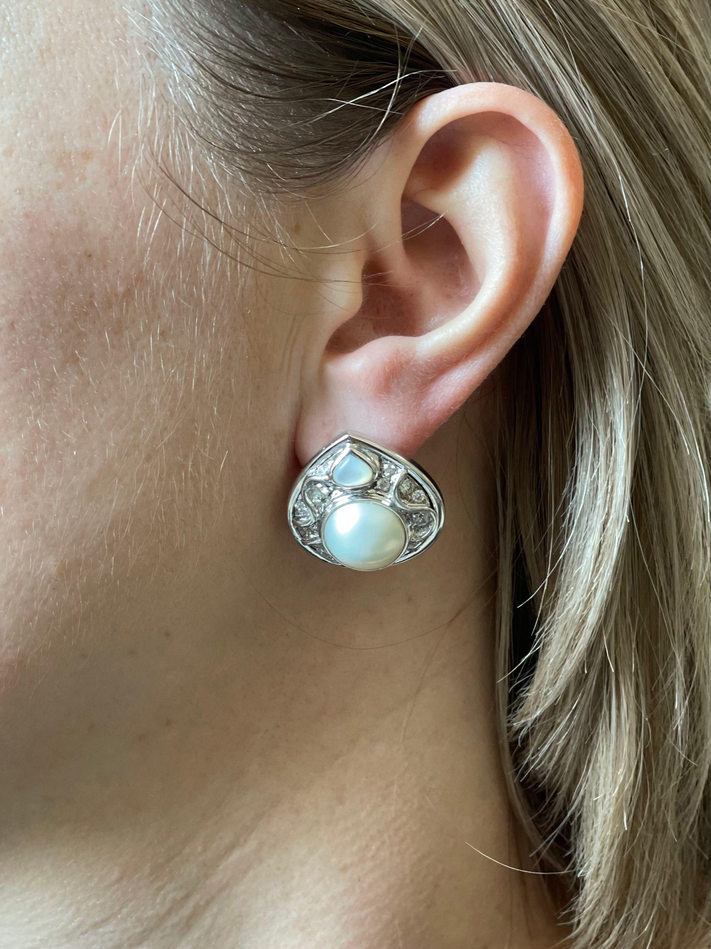 Pair of 18k white gold earrings by Marina B, set with mother of pearl, 12.5mm mabe pearls in the center, surrounded with approx. 0.40ctw G/VS diamonds. Earrings measure 1