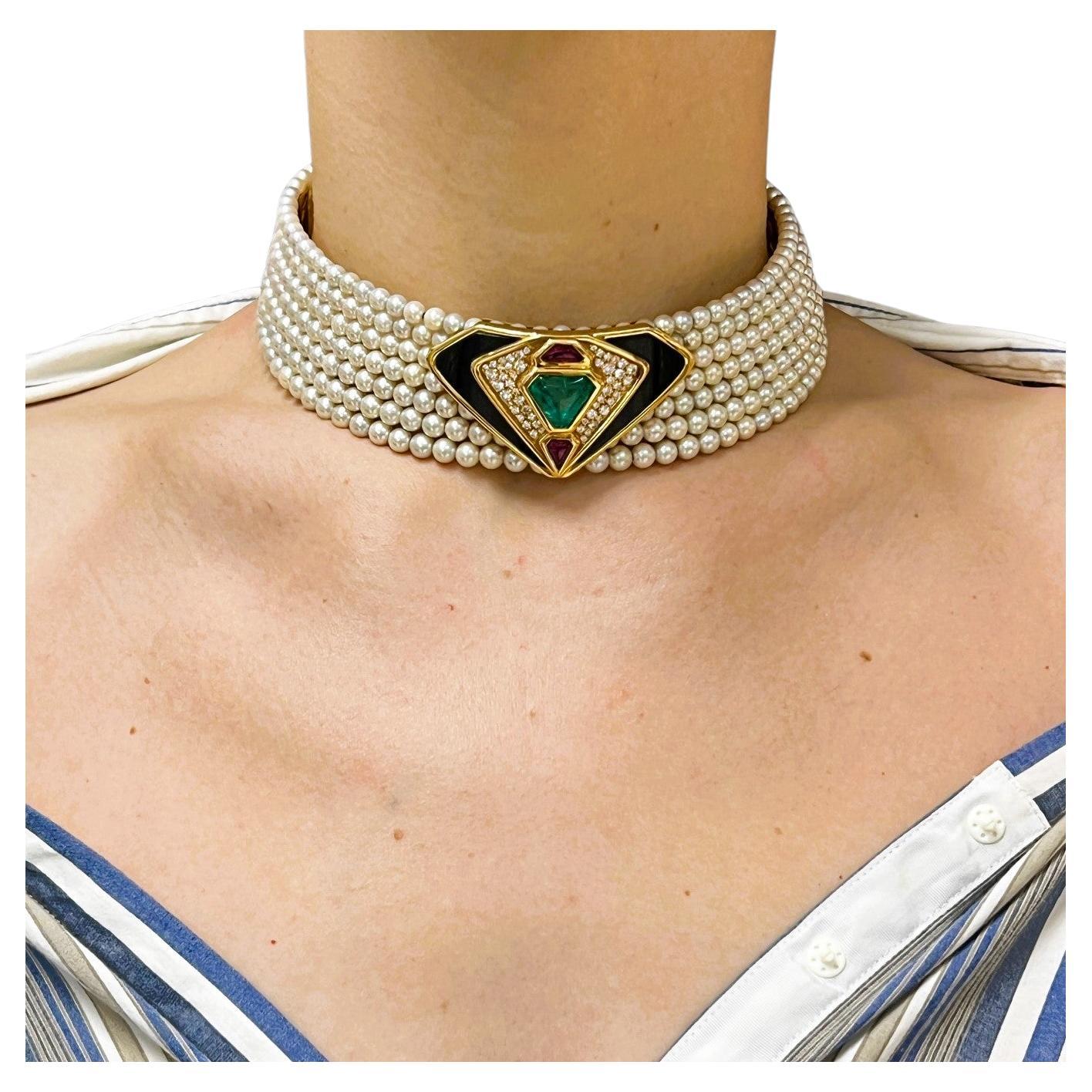 A spectacular vintage collar necklace by Marina B, crafted from pearls and featuring a calf’s head shaped cabochon emerald accented with diamonds, ruby and black onyx set in 18 karat yellow gold.
The seven-strand pearl choker is centered by a calf’s