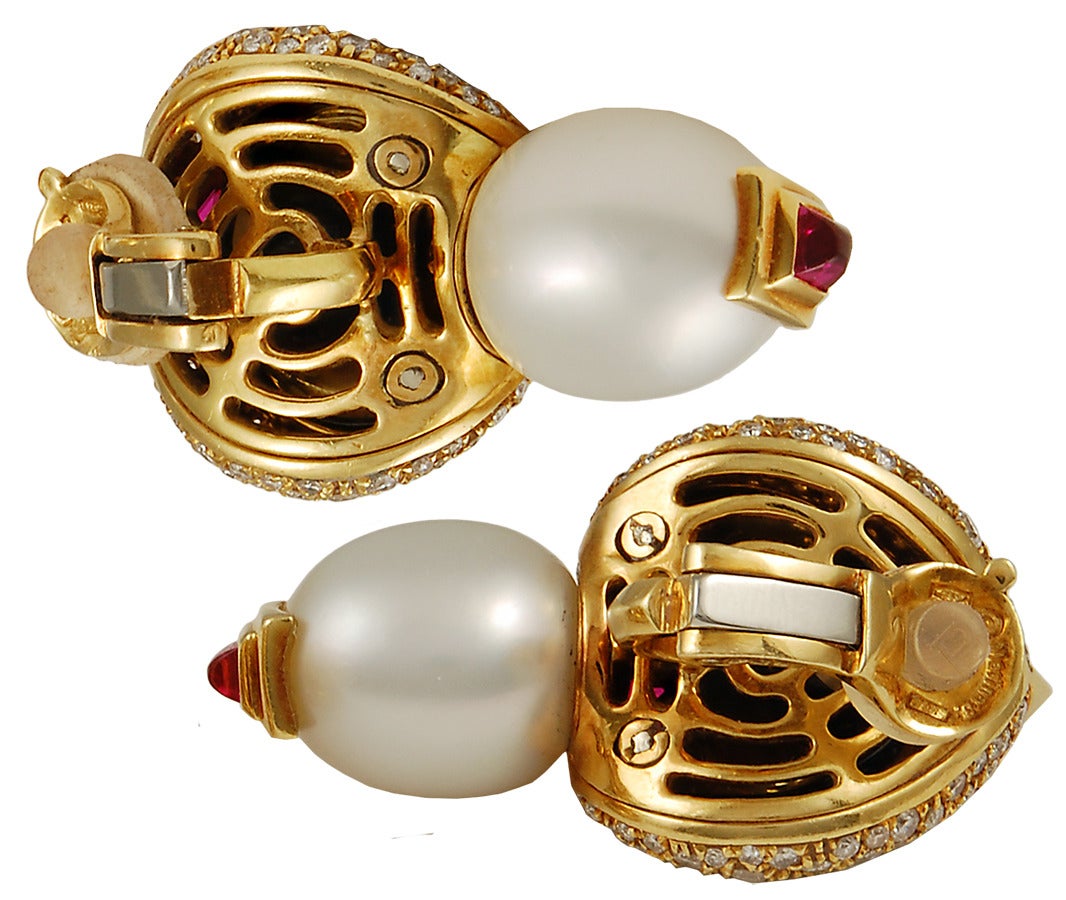 A pair of Marina B. gem-set ear clips in 18k gold; each designed as a button pearl set within a scooped onyx surround with pave-set diamond trim between two square pink tourmalines, and suspending a drop pearl with a cabochon tourmaline