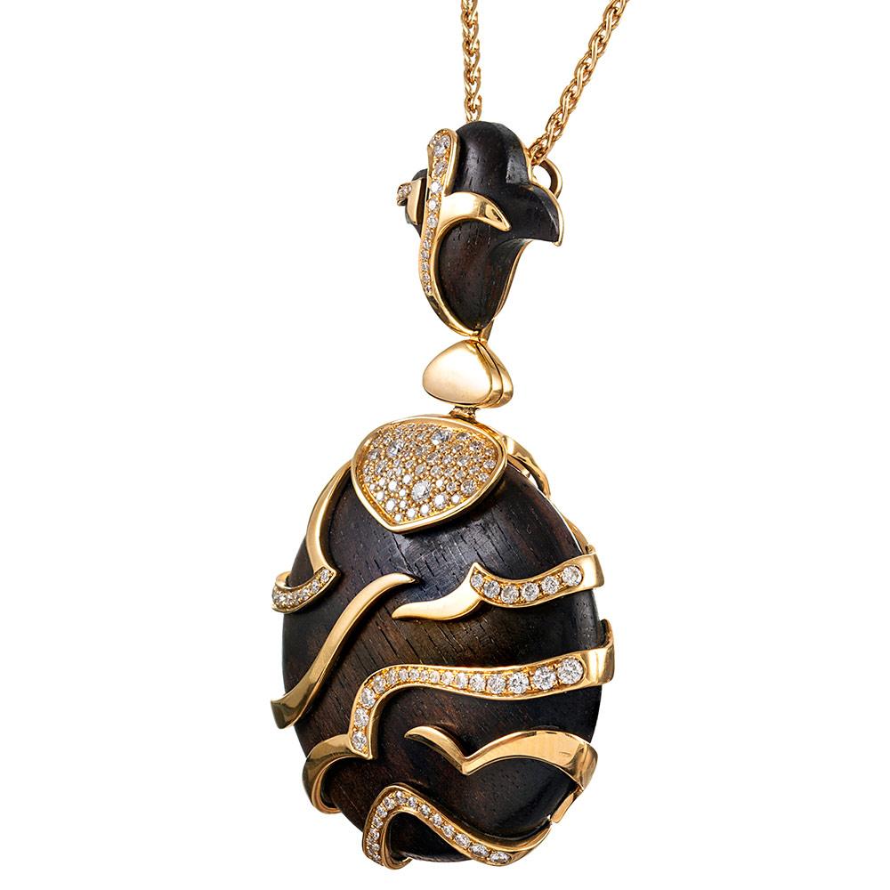 A substantial and exotic creation, compliments of Marina B, the piece is designed as a wood disc, suspended from a sculpted bale and decorated with golden tiger stripes and brilliant white diamonds. The pendant has been embellished with 1.05 carats