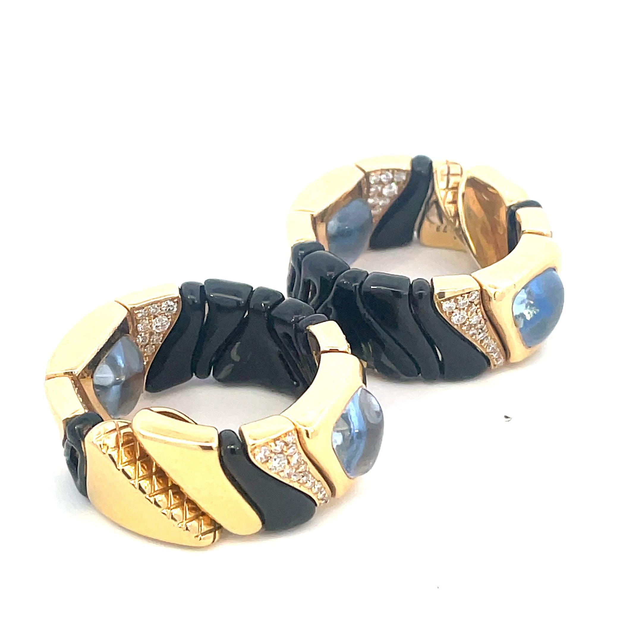 Bold and chic hoop earrings created by Marina B in 1987. 
Elegant and wearable, the earrings are a great addition to your jewelry collection.
The earrings are made of 18 karat (stamped) yellow gold and black enamel, triangle cabochon aquamarine and