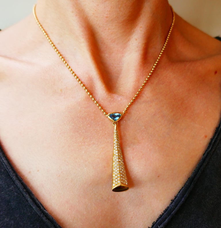 Chic articulated necklace created by Marina B in 1980s. Elegant and wearable, the necklace is a great addition to your jewelry collection. 
The necklace is made of 18 karat yellow gold, set with a triangle faceted blue topaz and encrusted with
