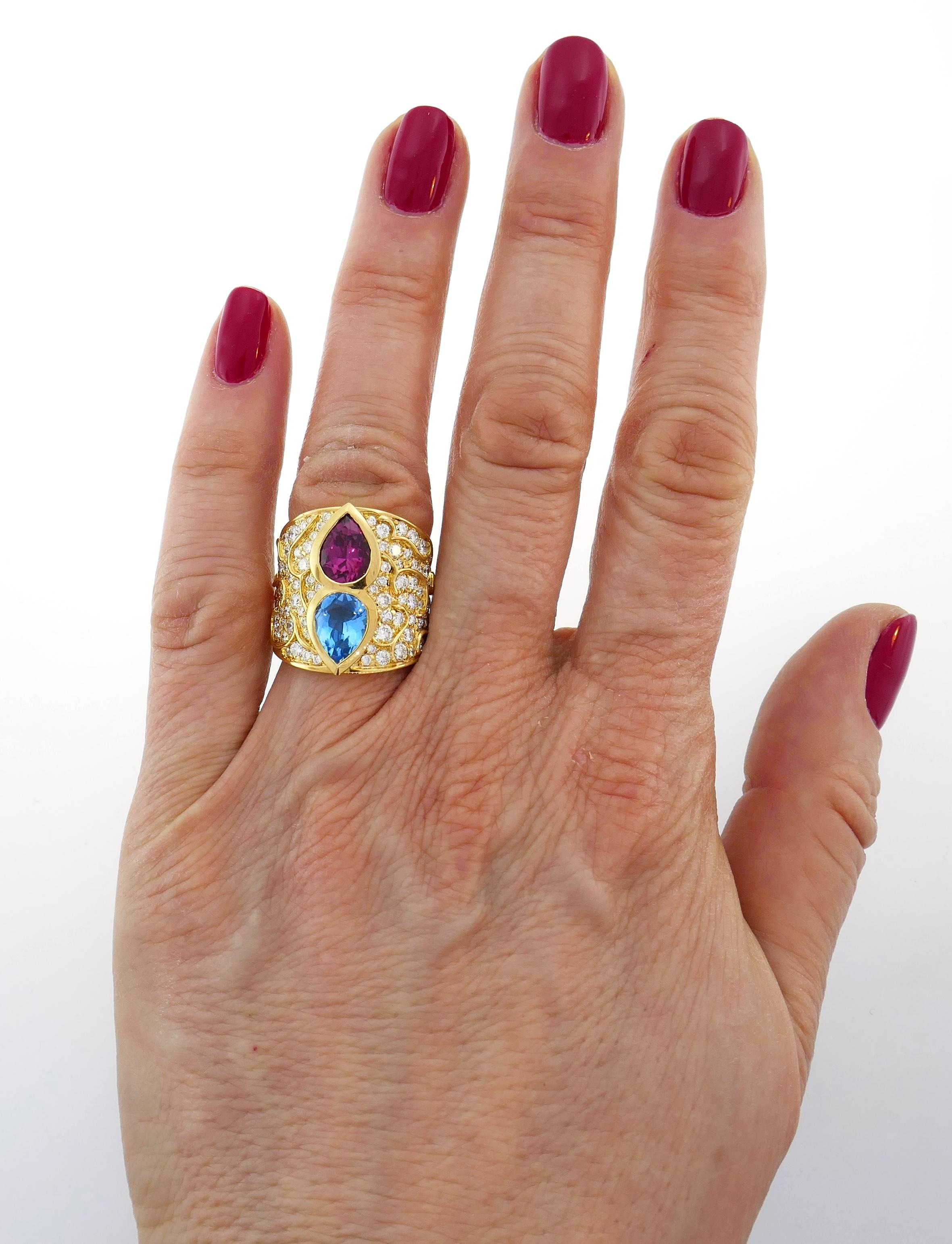 Colorful and chic cocktail ring created by Marina B in 1980s. The ring features a pear-shape blue topaz and purple tourmaline set in 18 karat yellow gold encrusted with a hundred round brilliant cut diamonds (G color, VS1 clarity, total weight