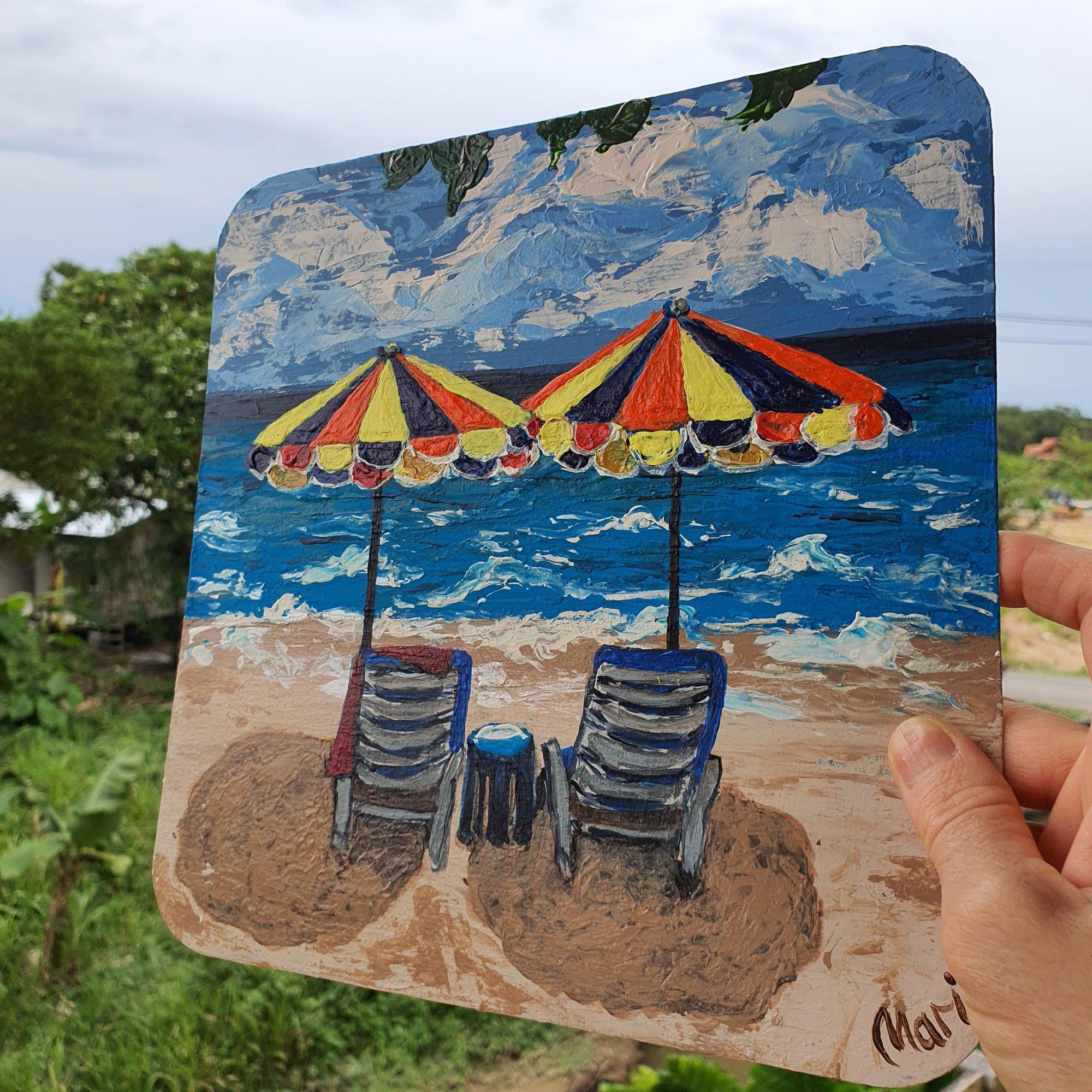 Este original cuadro acrílico costero representa una apacible vista del océano con sillas de playa y sombrillas, invitándote a relajarte. Ideal para los amantes del océano que buscan llevar un toque de la costa al interior.