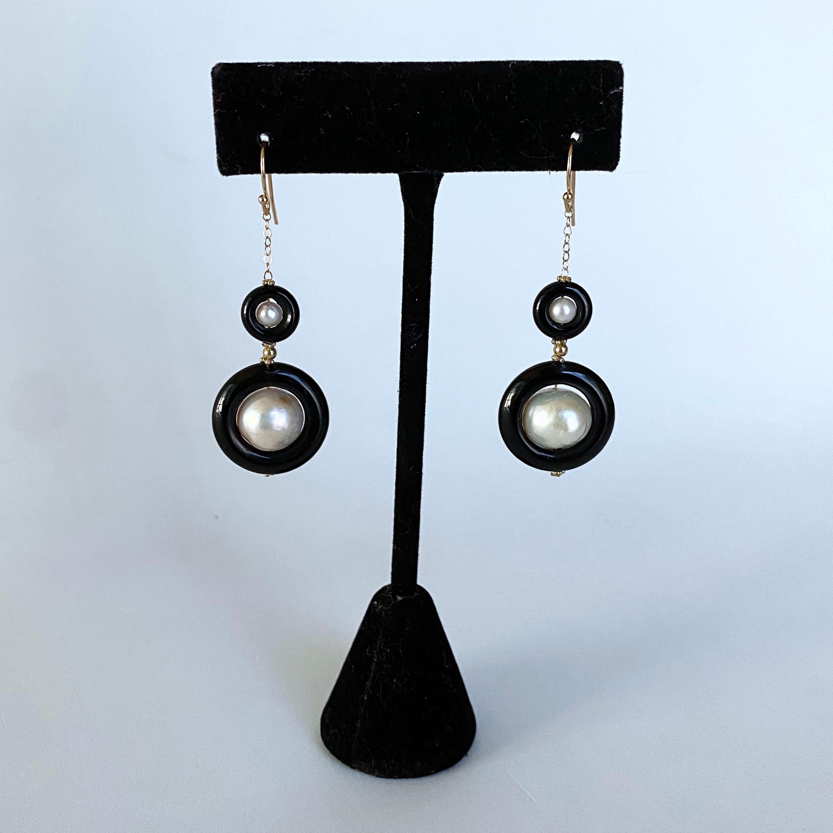 Stunning pair of Earrings by Marina J. This 2 tier Pearl and Black Onyx set features white Pearls displaying a beautiful iridescent sheen and texture, sitting inside Black Onyx donuts. The Pearl and Black Onyx Graduate in size and are separated by