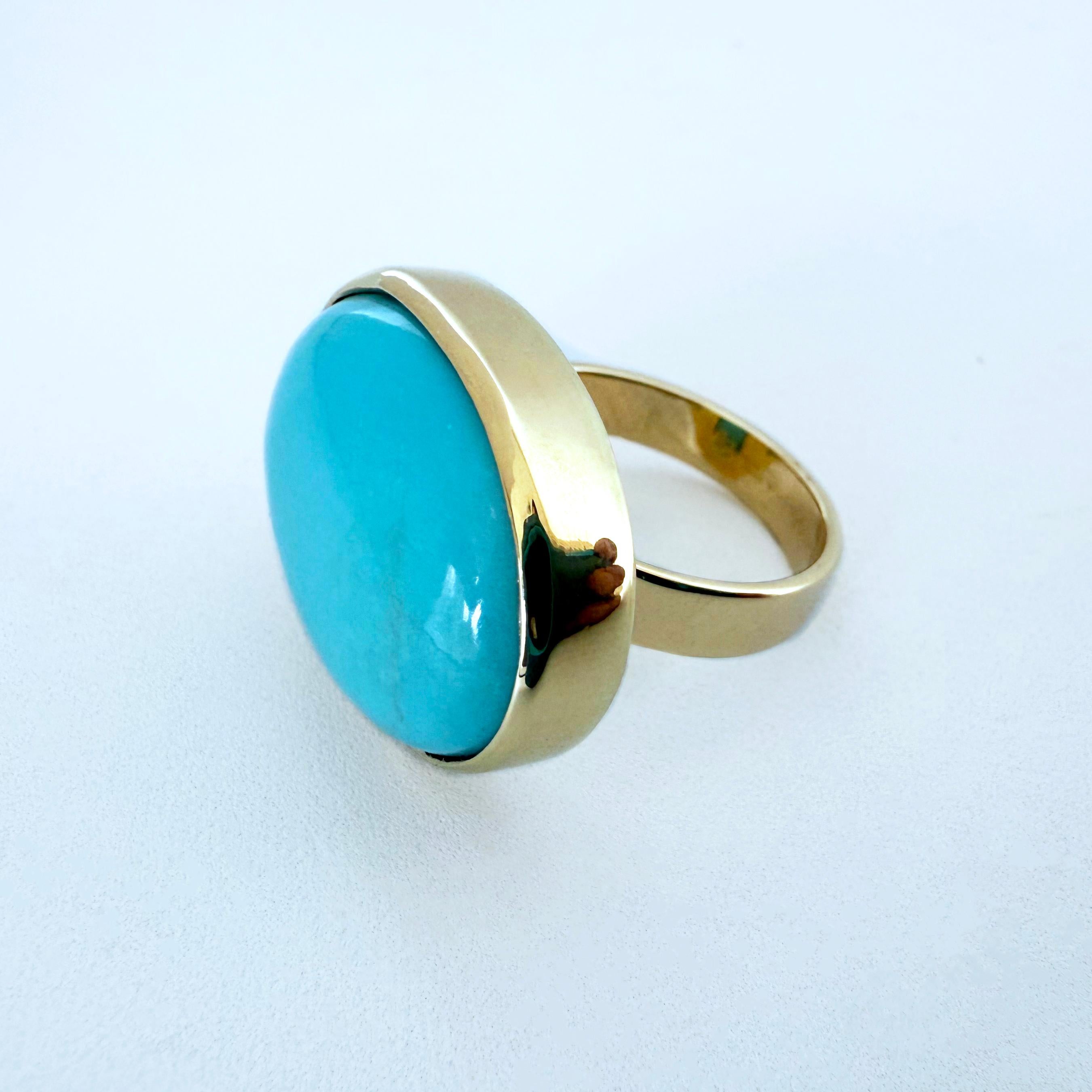 Gorgeous Large oval Sleeping Beauty Turquoise Cocktail Ring by Marina J. This piece is made with a large 26 carat Turquoise bezel set in Solid 14k Yellow Gold. Measuring a size 7, this ring includes 7 grams of Solid 14k Yellow Gold total. 
The