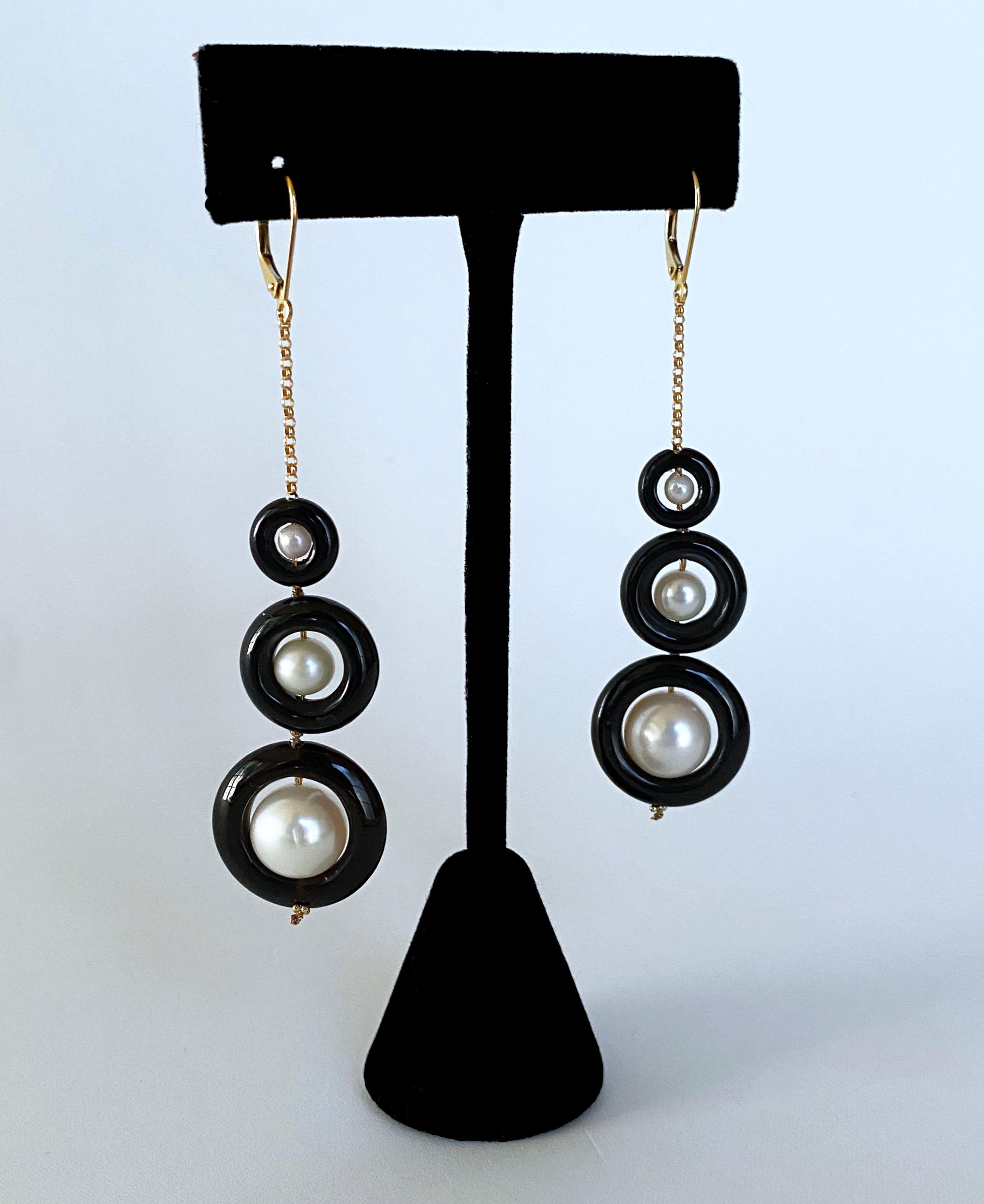 Stunning pair of Earrings by Marina J. This pair feature round white Pearls with a soft iridescent sheen, all sitting inside round Black Onyx donuts. The Pearls and Black Onyx Graduate in size making a 3 tier Hanging Earring. Both pieces in this set