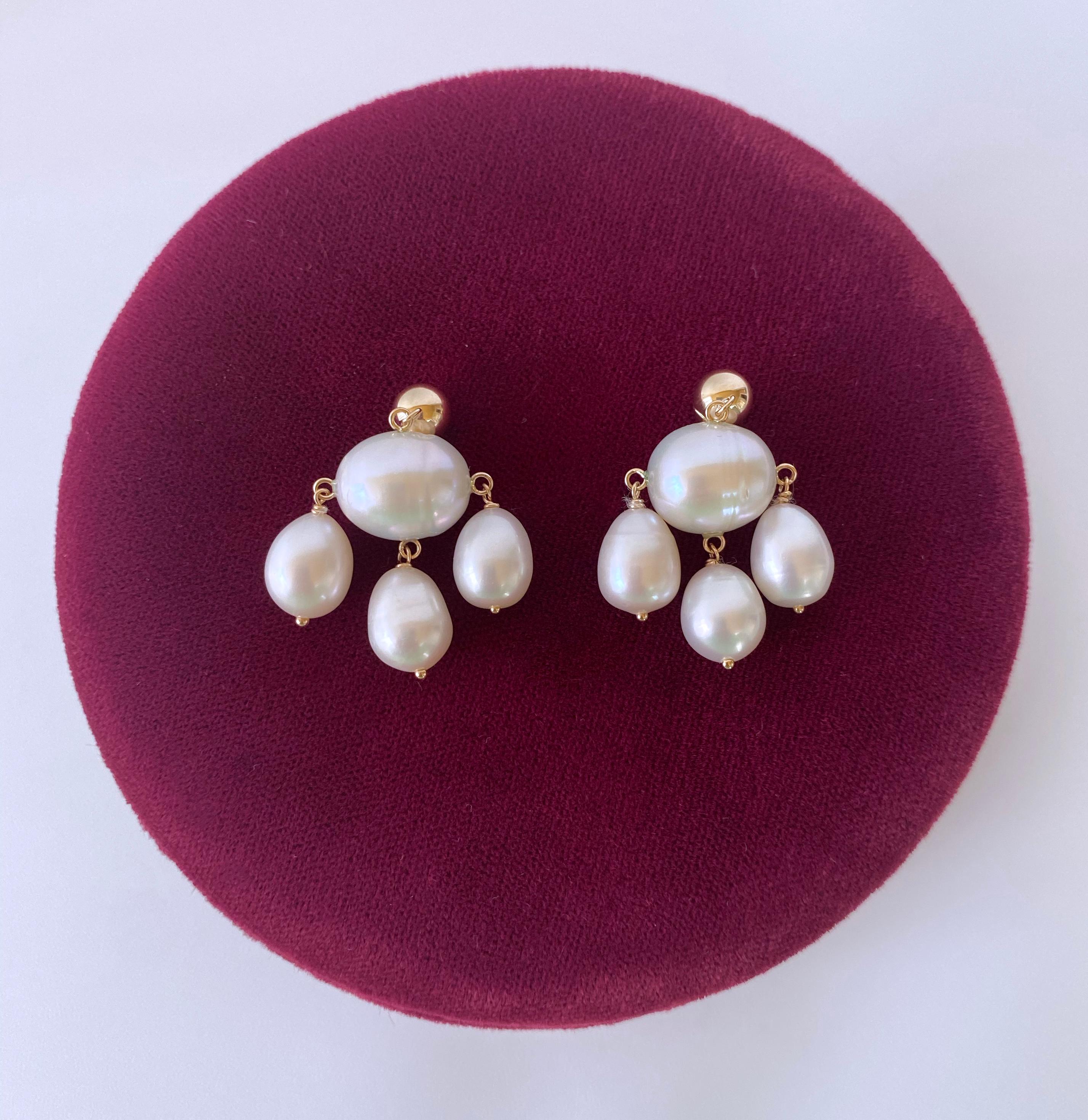 Gorgeous pair of chandelier handmade earrings by Marina J. This lovely pair feature high luster white Pearls that display beautiful hues of different colors when hit with light. A large Baroque Oval Pearl hangs in the middle, from which three
