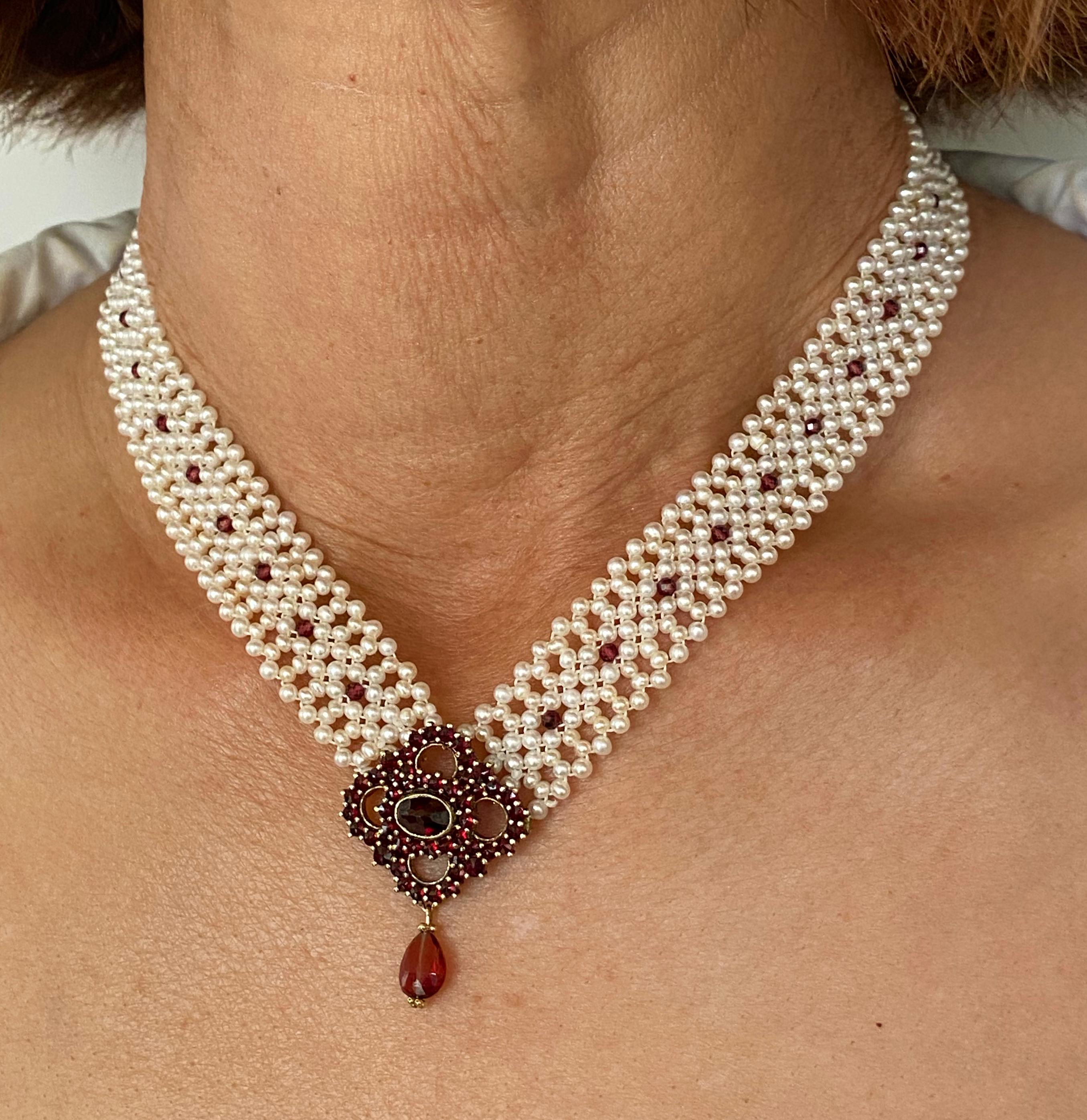Wunderschöne 'V' Halskette von Marina J. Dieses wunderbare Stück besteht aus weißen Zuchtperlen, die in einem engen, spitzenähnlichen Design miteinander verwoben sind. Kleine Granatperlen sind in das Band aus gewebten Perlen eingewebt. Eine