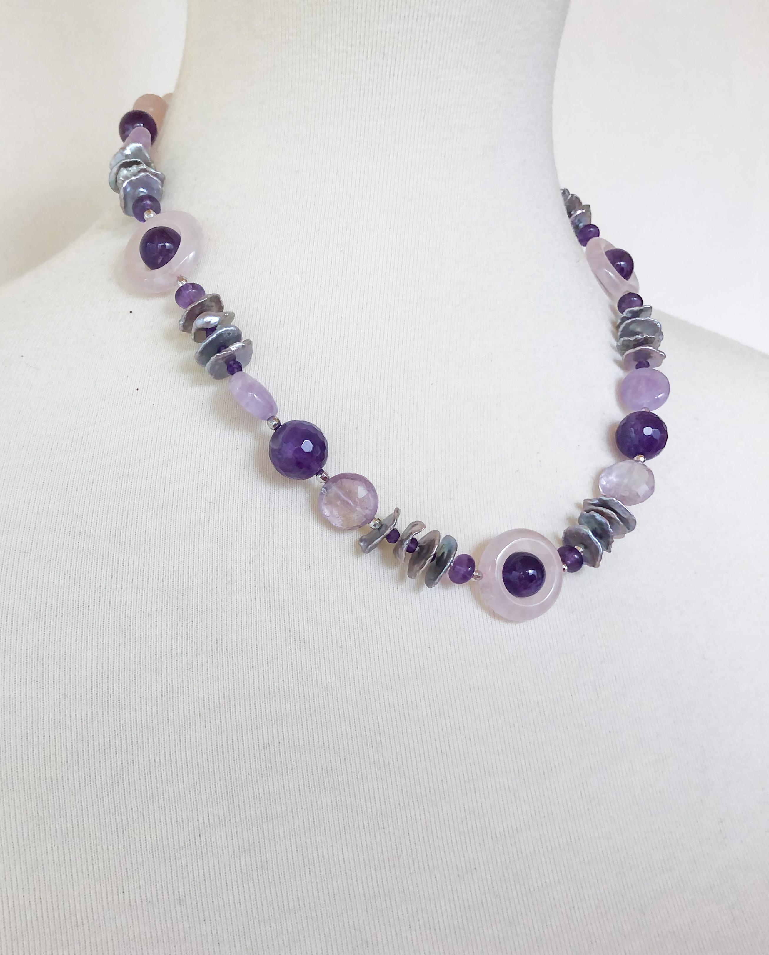 This necklace is made with various shapes and shades of amethyst, as well as rose quartz and freshwater graded grey pearls. There are also tiny amethyst and silver rhodium plated beads in between the gems for a pop of color. The necklace is 18